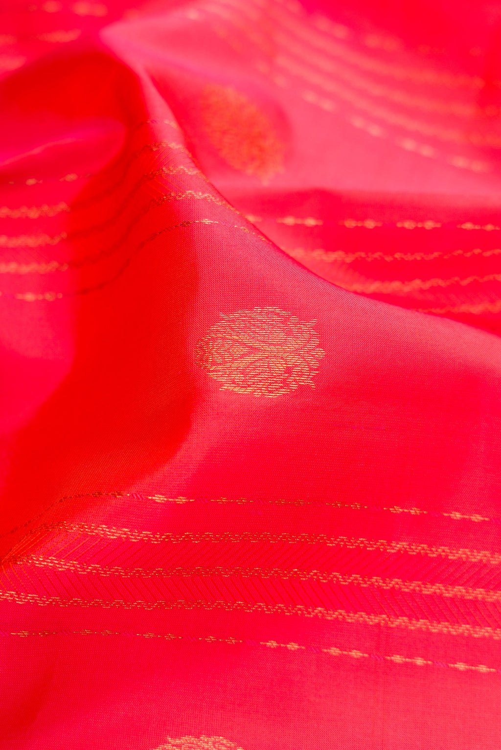 Close up of Coral Dual Tone Kanchipuram Silk Saree with Jacquard With Zari Butta on the body and Zari Border.  displaying folds