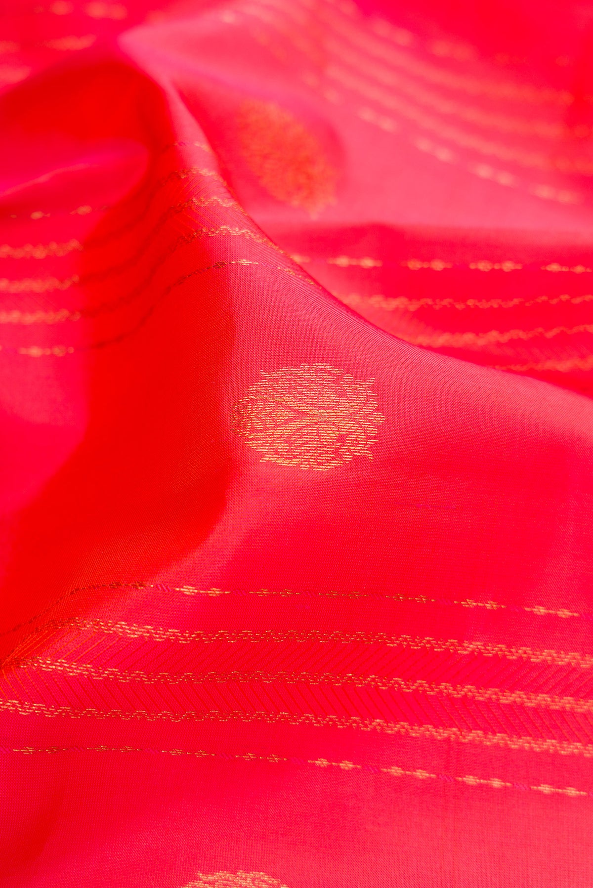 Close up of Coral Dual Tone Kanchipuram Silk Saree with Jacquard With Zari Butta on the body and Zari Border.  displaying folds