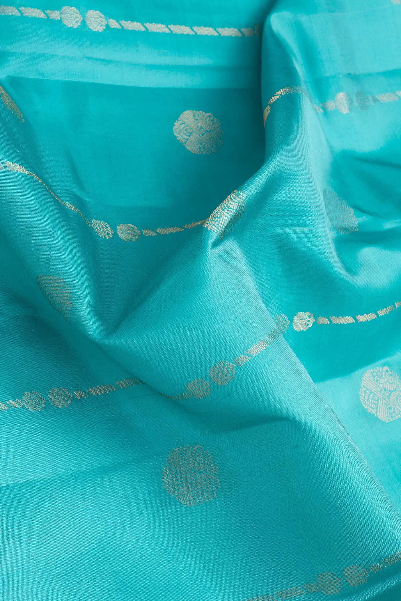 Close up of Sky Blue Dual Tone Kanchipuram Silk Saree with Zari Butta on the body and Zari Border.  displaying folds