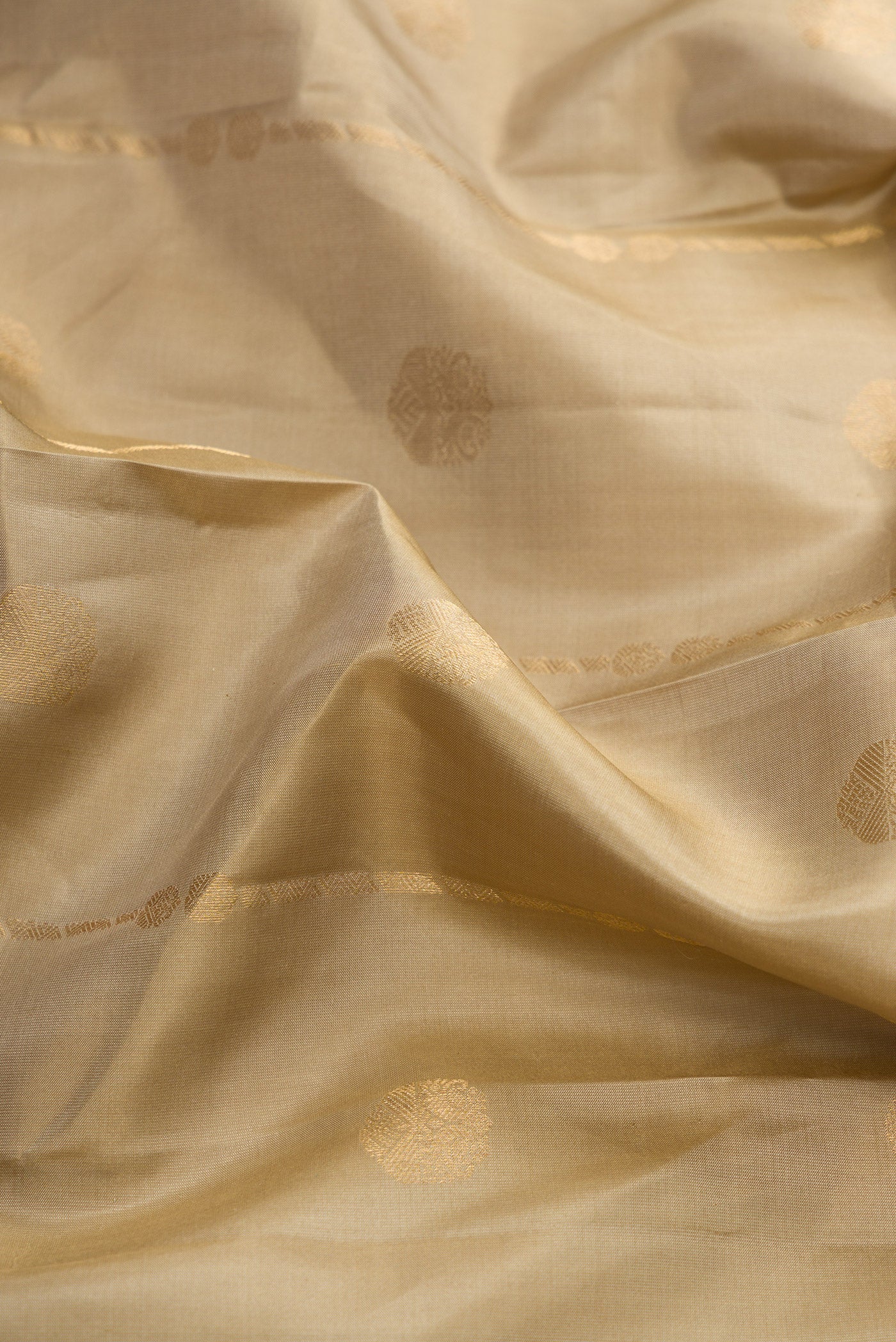Close up of Dark Beige Dual Tone Kanchipuram Silk Saree with Zari Butta on the body and Zari Border.  displaying folds
