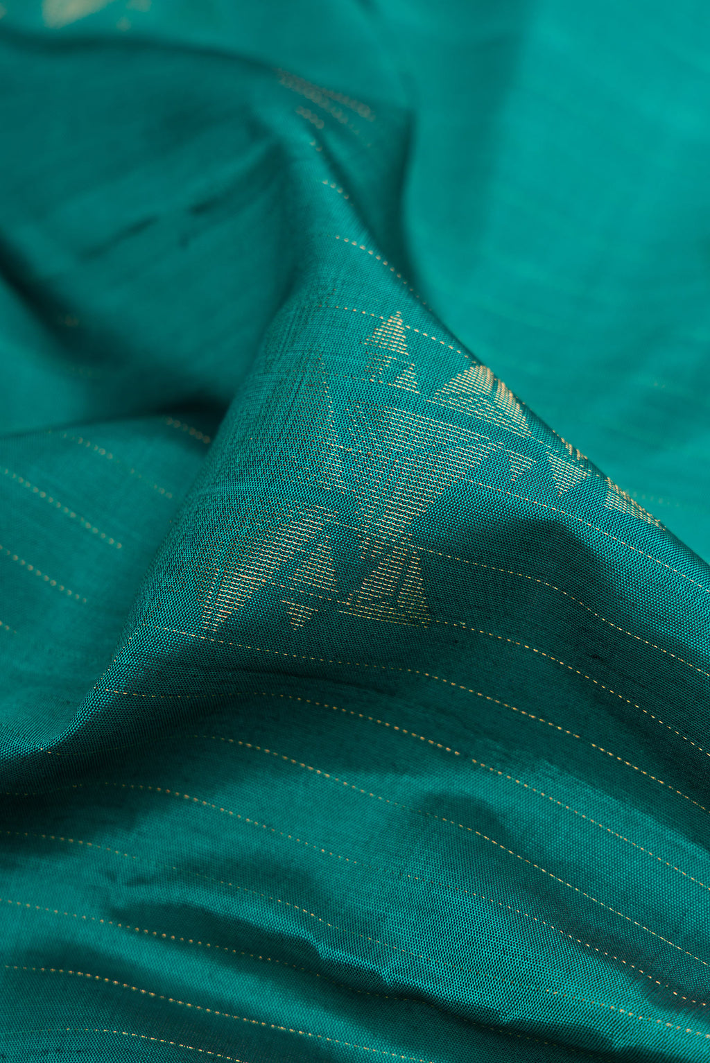 Close up of Green Dual Tone Soft Silk Saree with Zari Butta on the body and Without Border.  displaying folds