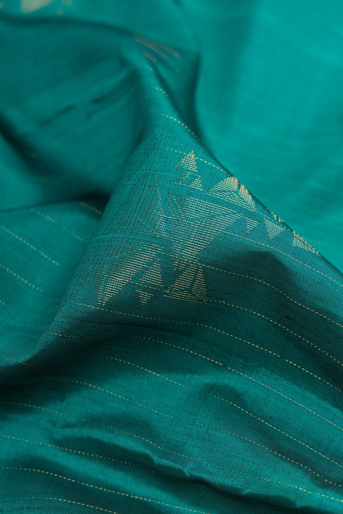 Close up of Green Dual Tone Soft Silk Saree with Zari Butta on the body and Without Border.  displaying folds