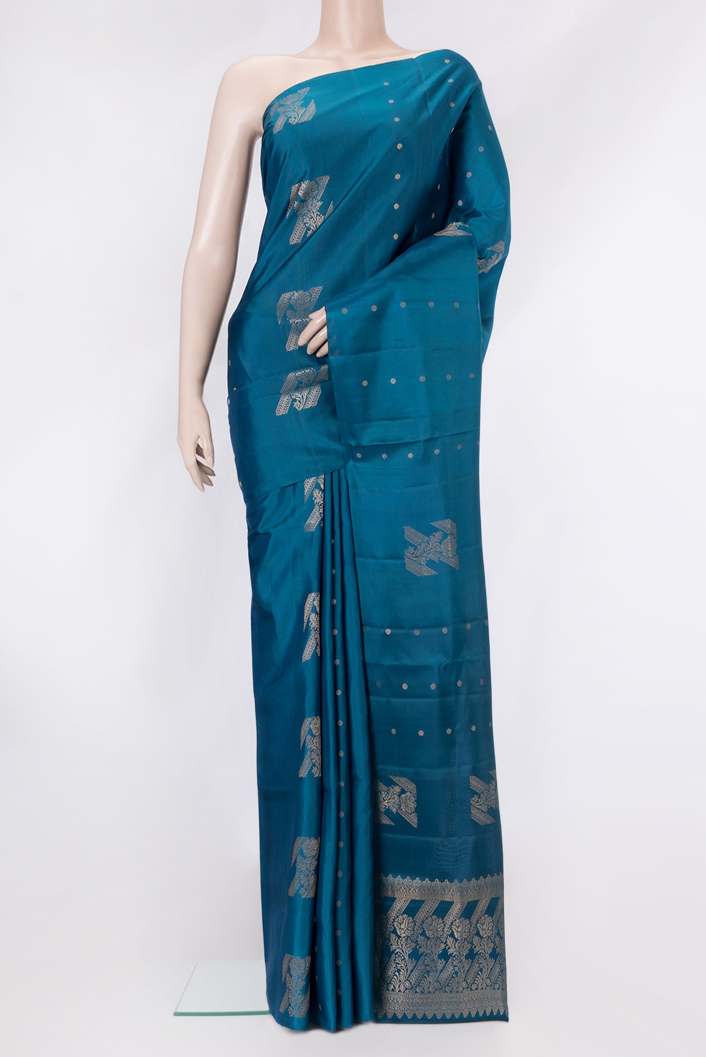 Peacock Blue Soft Silk Saree with Zari Butta on the body and Without Border.  displayed on a mannequin