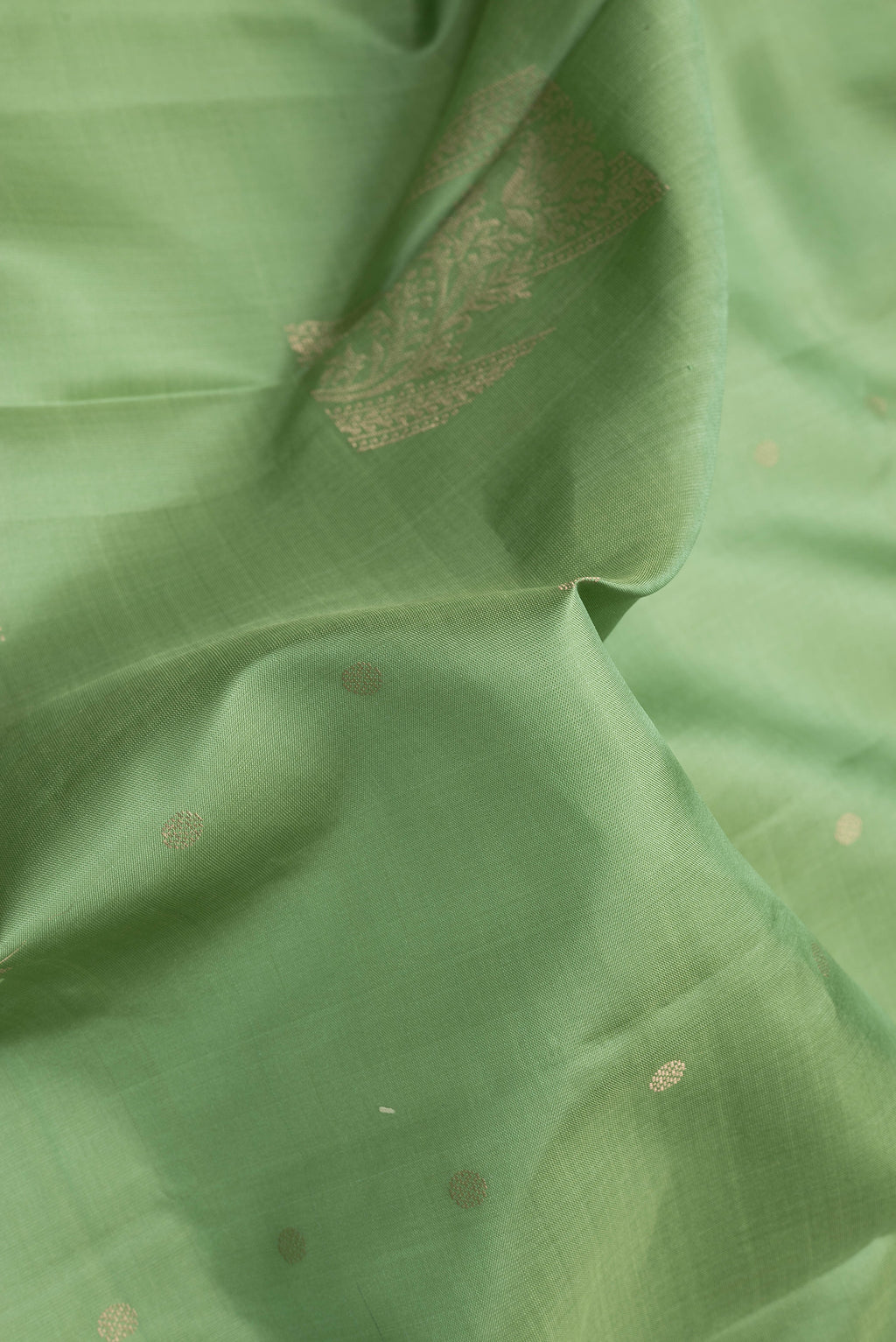 Close up of Sea Green Soft Silk Saree with Zari Butta on the body and Without Border.  displaying folds