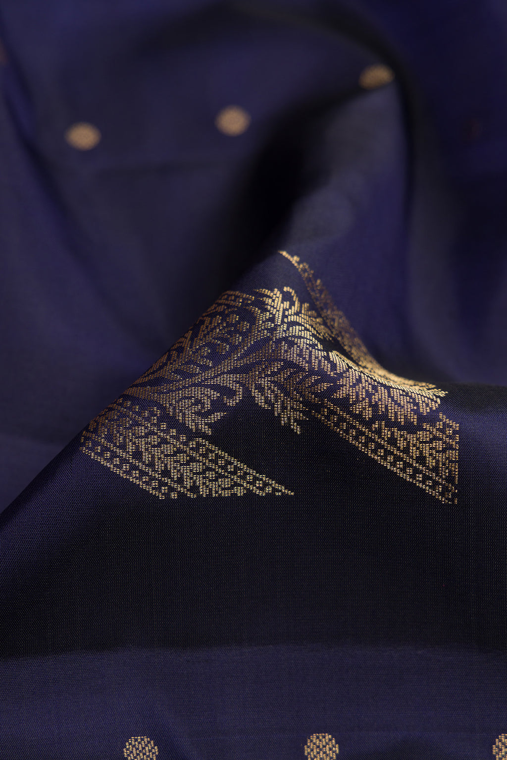 Close up of Navy Blue Dual Tone Soft Silk Saree with Zari Butta on the body and Without Border.  displaying folds
