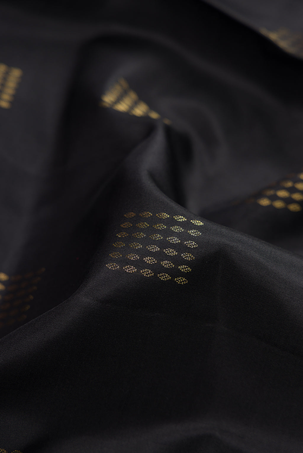 Close up of Black Dual Tone Soft Silk Saree with Zari Butta on the body and Fancy Border.  displaying folds