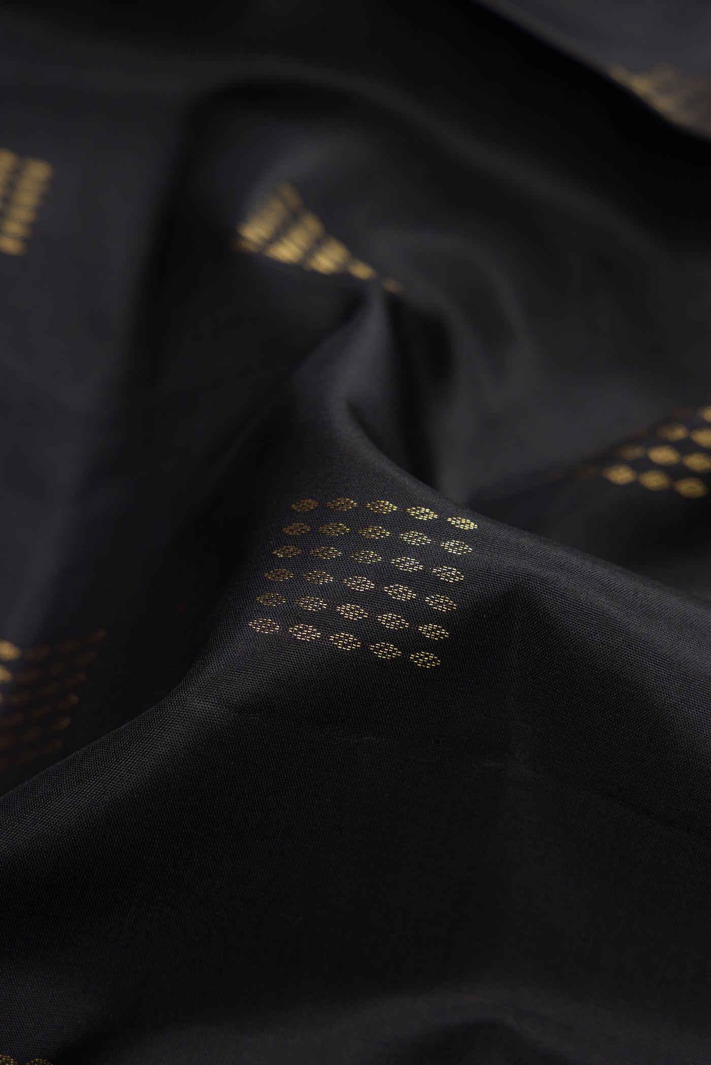 Close up of Black Dual Tone Soft Silk Saree with Zari Butta on the body and Fancy Border.  displaying folds