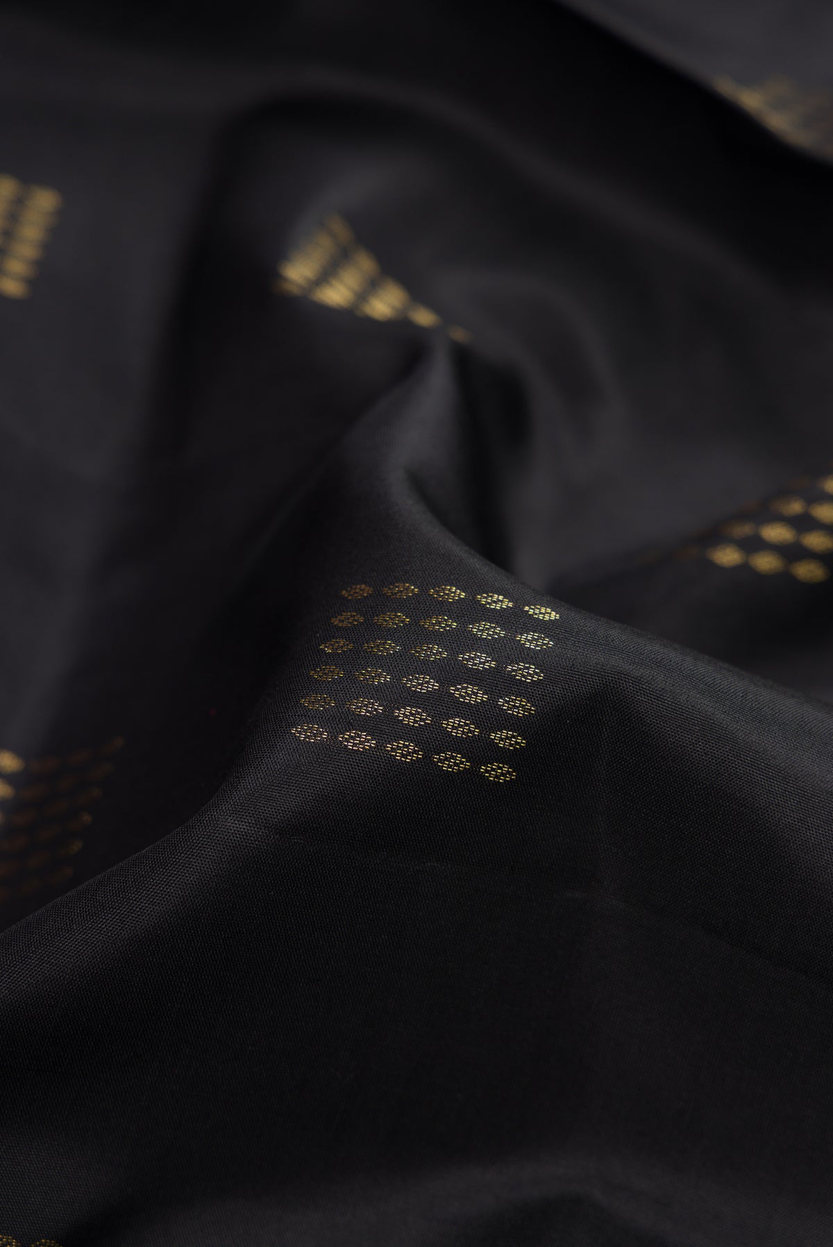 Close up of Black Dual Tone Soft Silk Saree with Zari Butta on the body and Fancy Border.  displaying folds