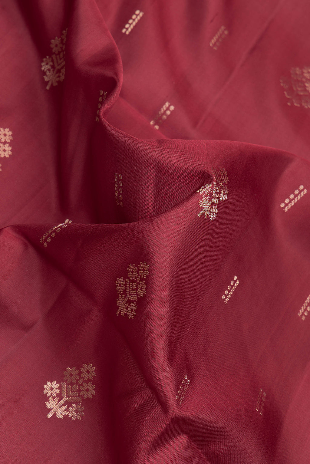 Close up of Maroon Soft Silk Saree with Zari Butta on the body and Zari Border.  displaying folds