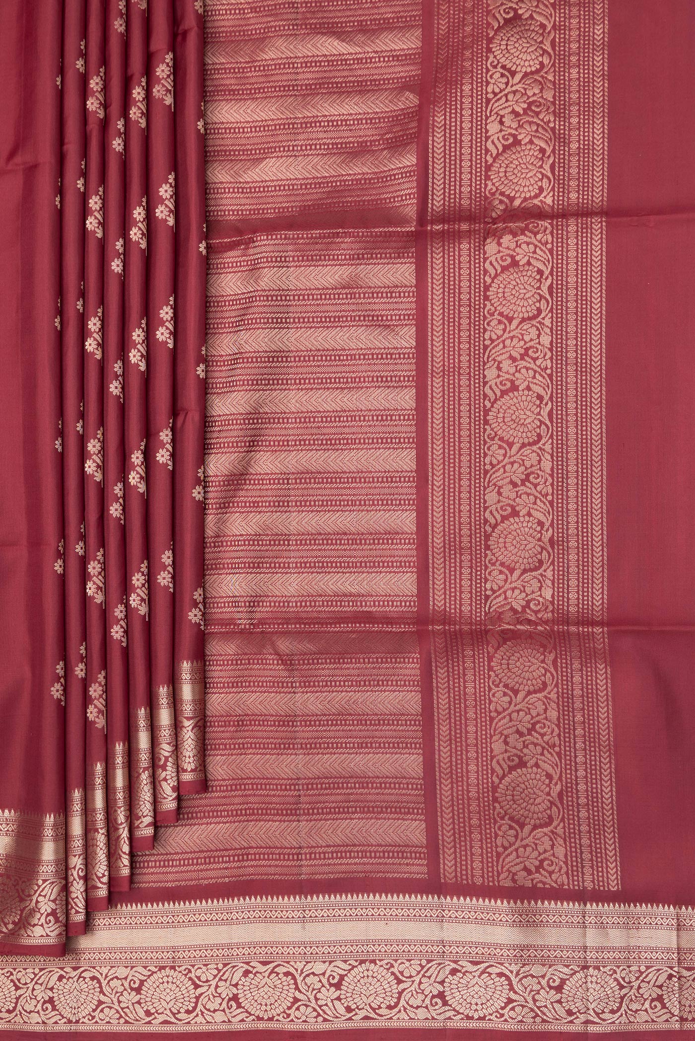 Pleats and pallu of Maroon Soft Silk Saree with Zari Butta on the body and Zari Border. 