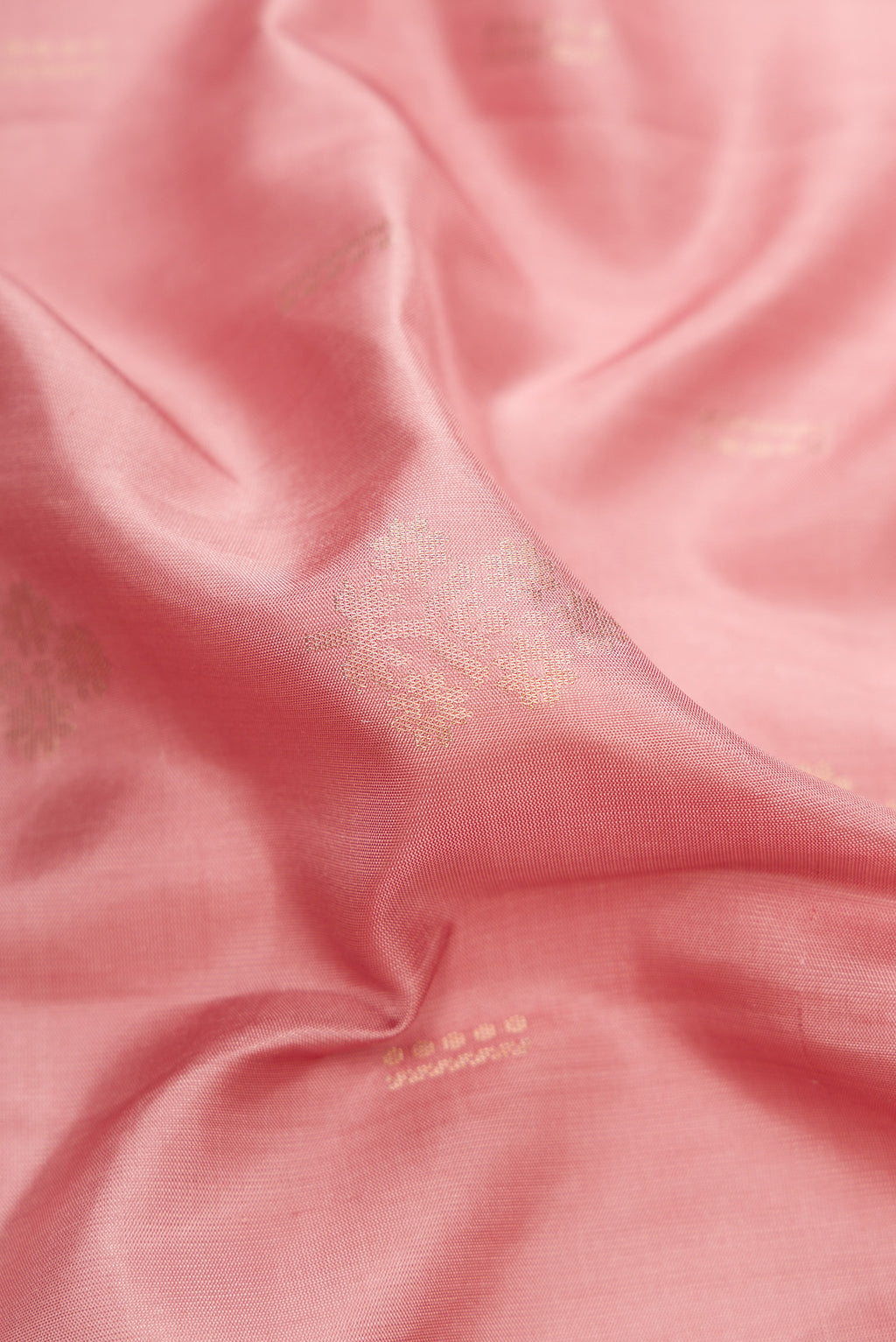 Close up of Rose Gold Dual Tone Soft Silk Saree with Zari Butta on the body and Zari Border.  displaying folds