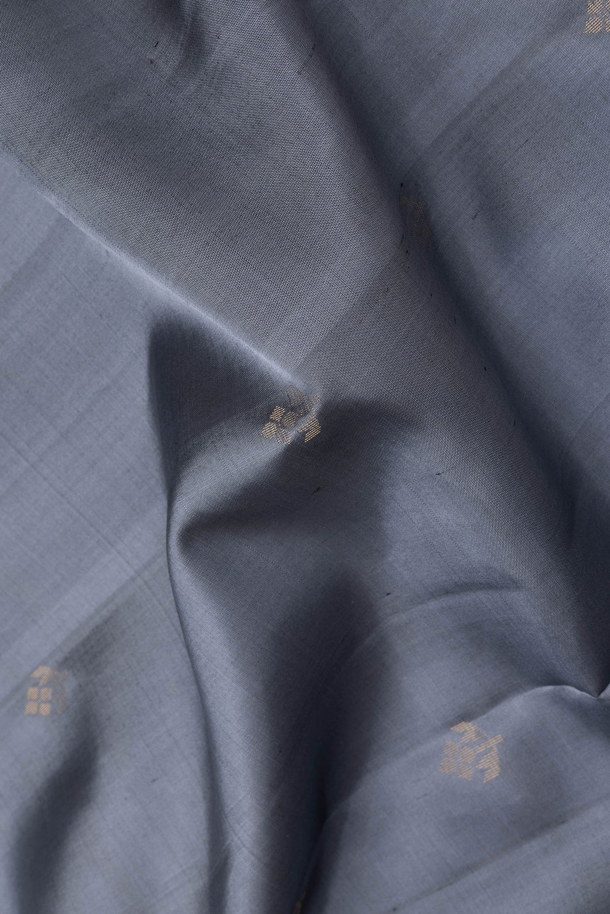 Close up of Grey Soft Silk Saree with Zari Butta on the body and Zari Border.  displaying folds
