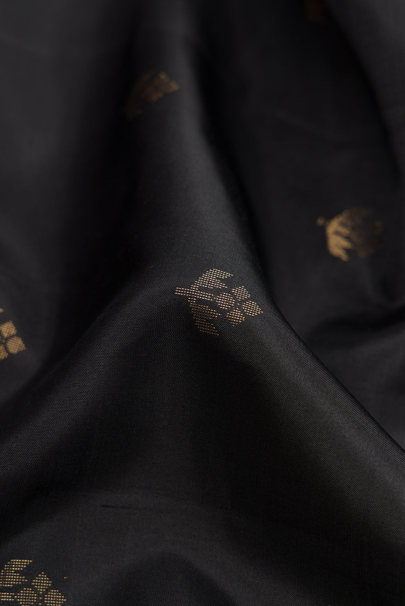 Close up of Black Dual Tone Soft Silk Saree with Zari Butta on the body and Zari Border.  displaying folds