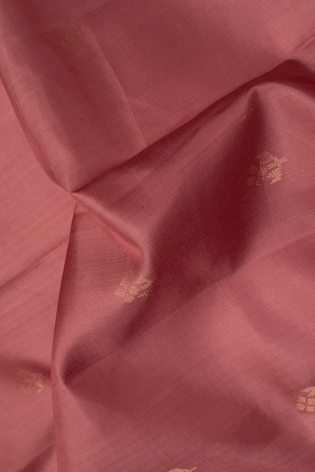 Close up of Rose Gold Dual Tone Soft Silk Saree with Zari Butta on the body and Zari Border.  displaying folds