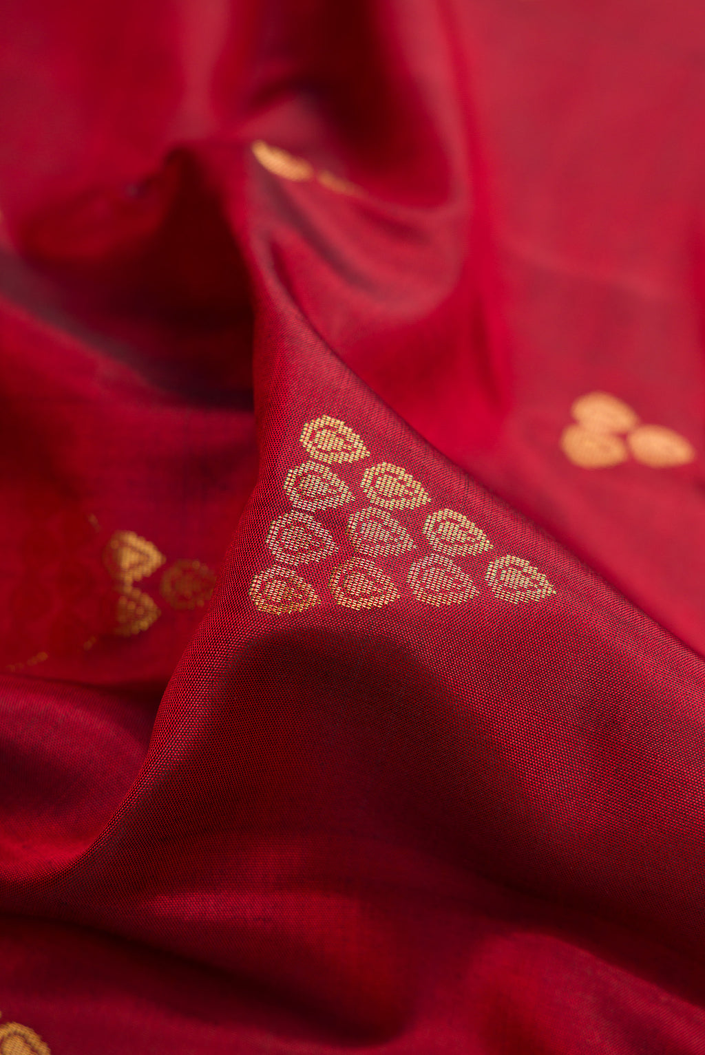 Close up of Maroon Dual Tone Soft Silk Saree with Zari Butta on the body and Zari Border.  displaying folds