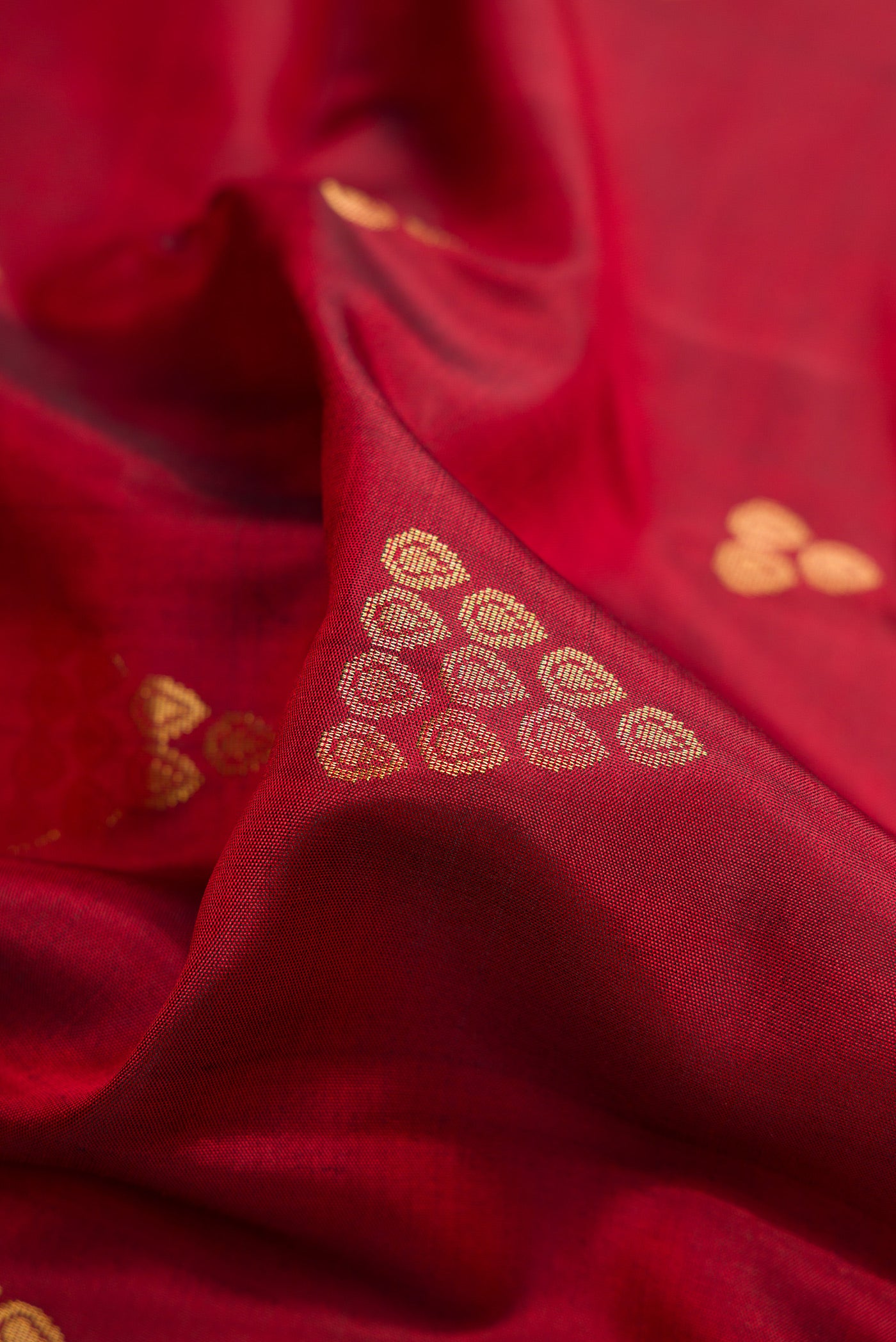 Close up of Maroon Dual Tone Soft Silk Saree with Zari Butta on the body and Zari Border.  displaying folds