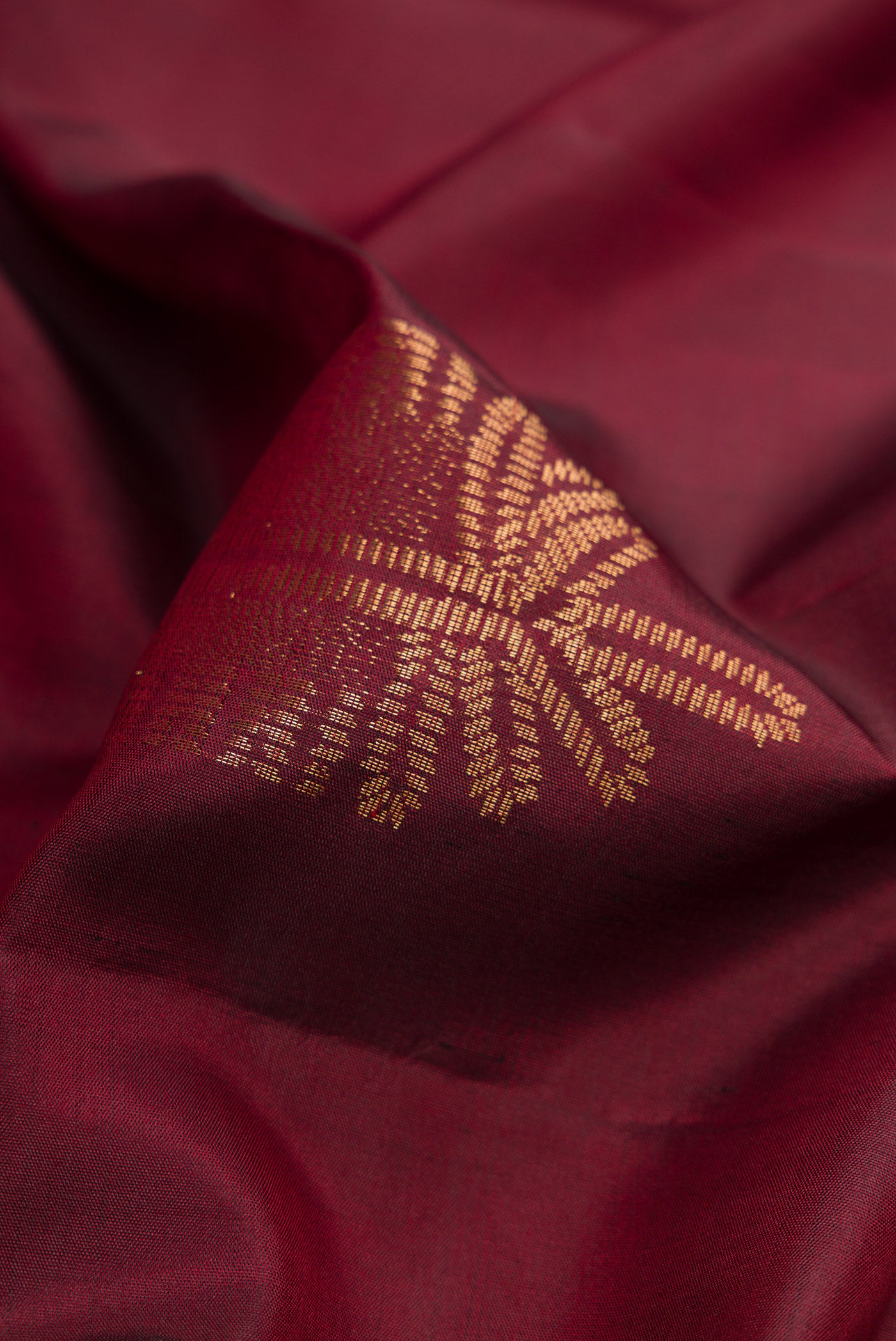 Close up of Maroon Dual Tone Soft Silk Saree with Zari Butta on the body and Without Border.  displaying folds