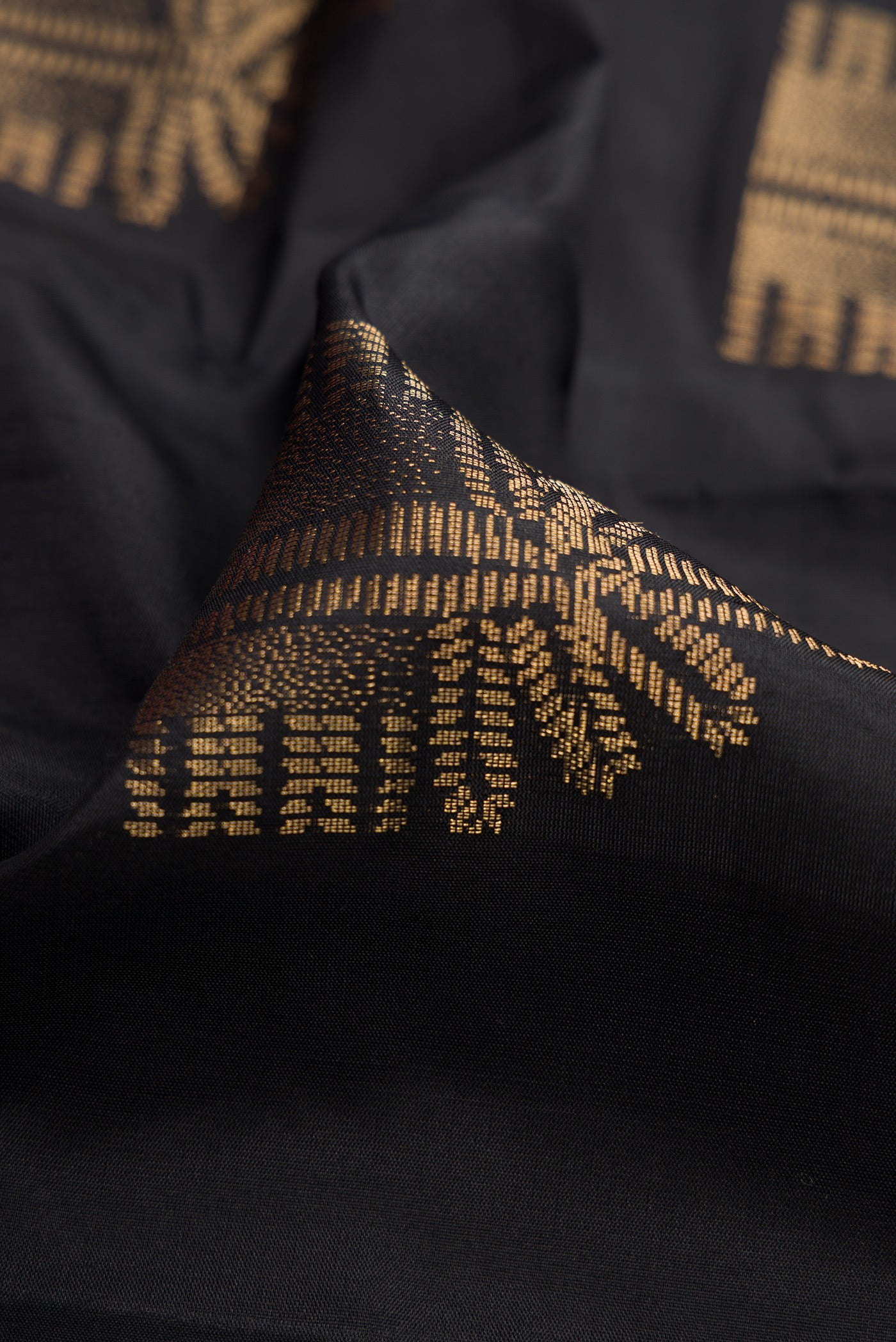 Close up of Black Dual Tone Soft Silk Saree with Zari Butta on the body and Without Border.  displaying folds