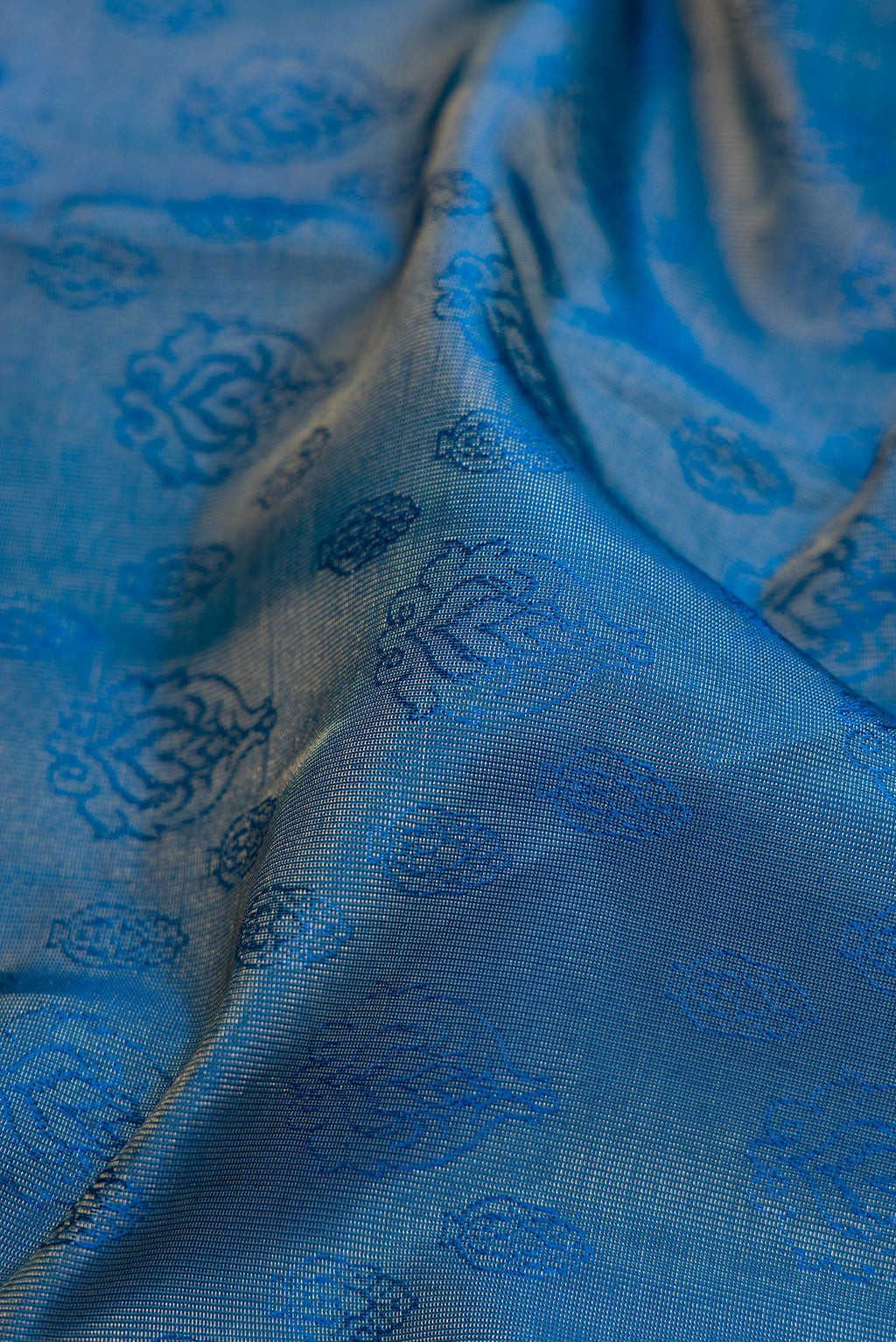 Close up of Maya Blue Dual Tone Kanchipuram Tissue Silk Saree with Zari Brocade on the body and Zari Border.  displaying folds