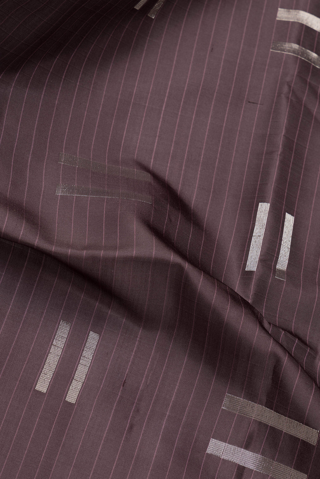 Close up of Coffee Brown Soft Silk Saree with Zari Butta on the body and Without Border.  displaying folds
