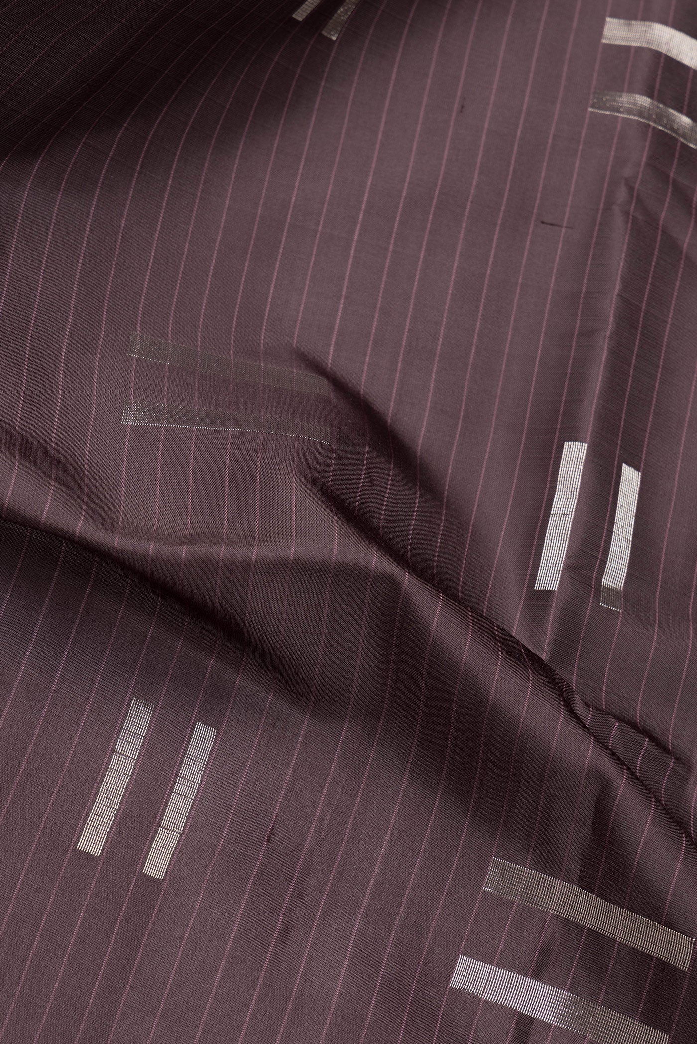 Close up of Coffee Brown Soft Silk Saree with Zari Butta on the body and Without Border.  displaying folds