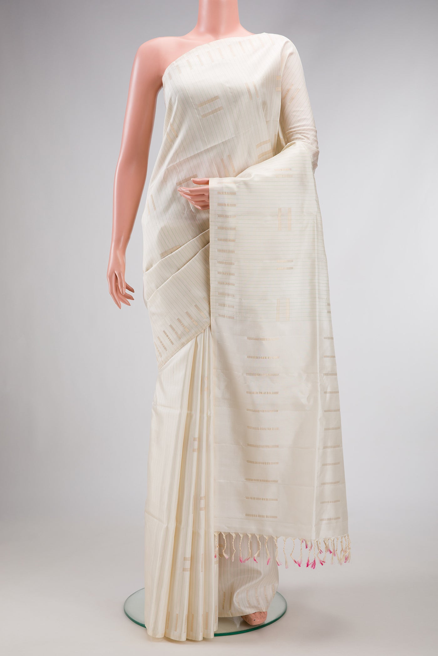Off White Dual Tone Soft Silk Saree with Zari Butta on the body and Fancy Border.  displayed on a mannequin