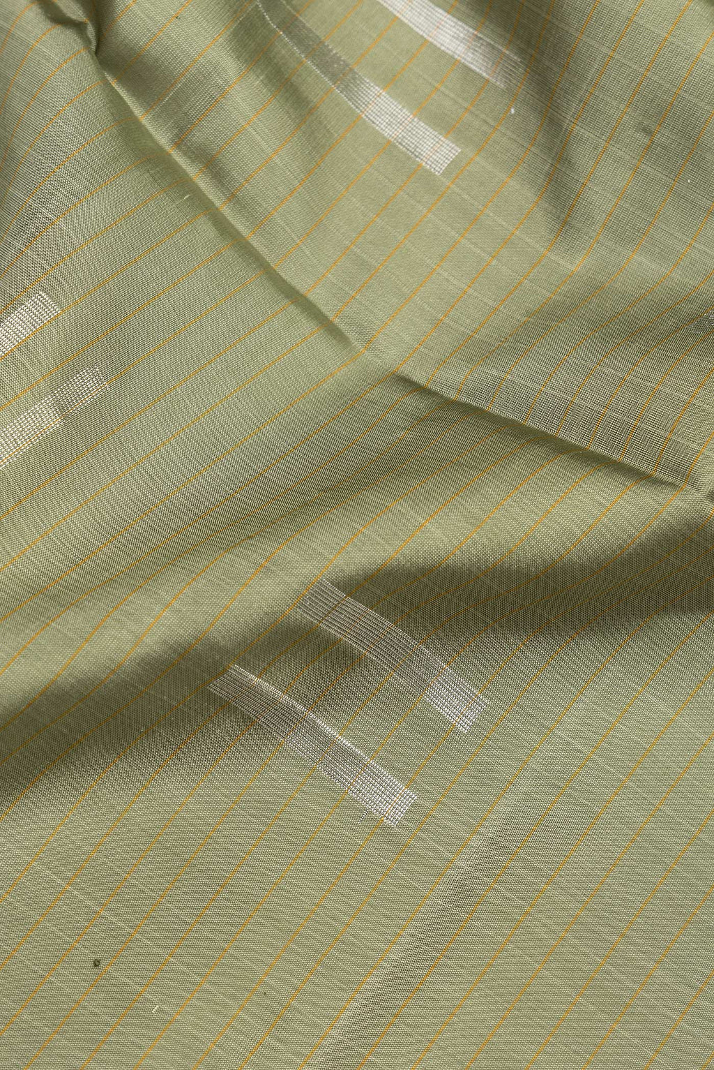 Close up of Pista Green Dual Tone Soft Silk Saree with Zari Butta on the body and Zari Border.  displaying folds
