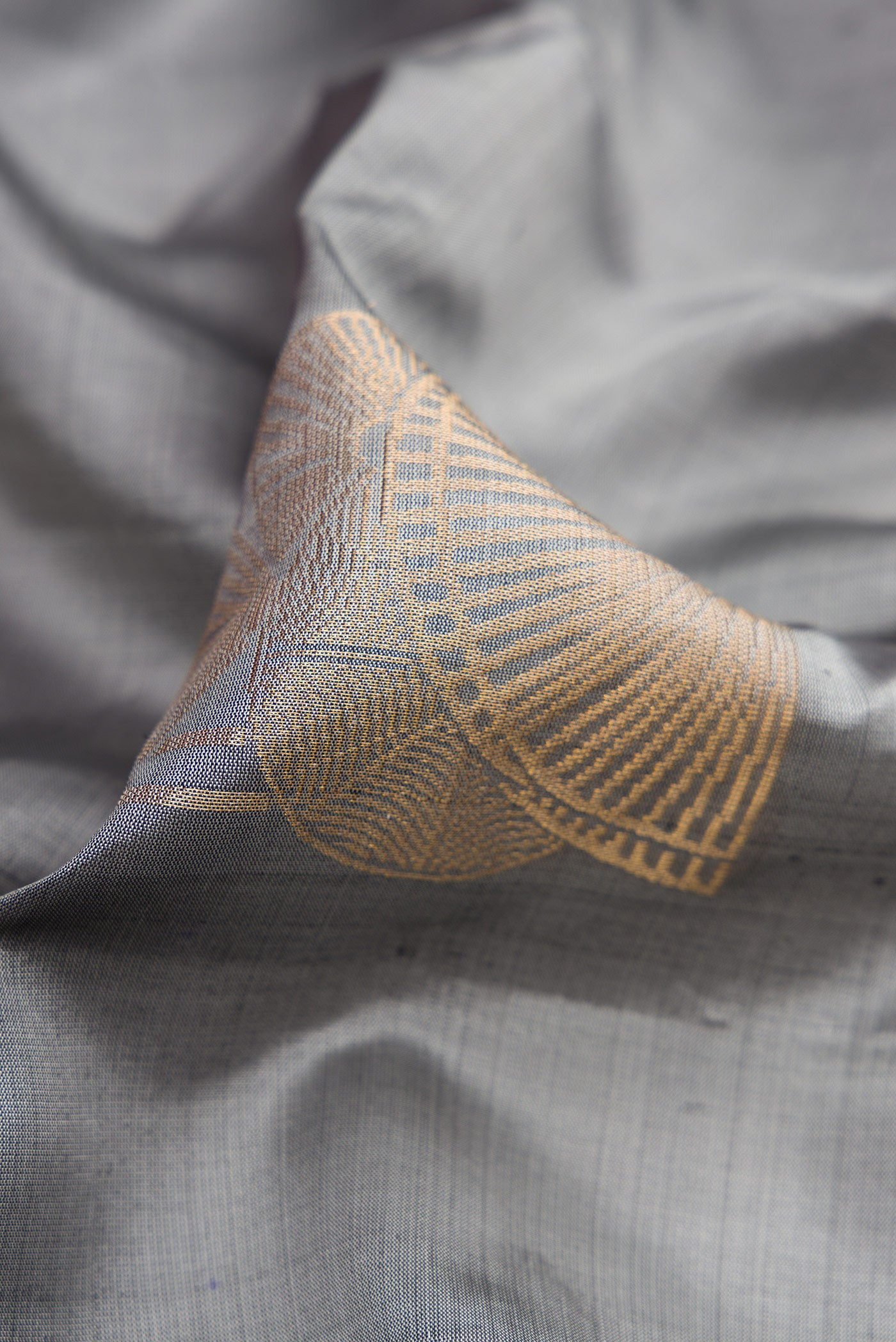 Close up of Grey Dual Tone Soft Silk Saree with Zari Butta on the body and Without Border.  displaying folds