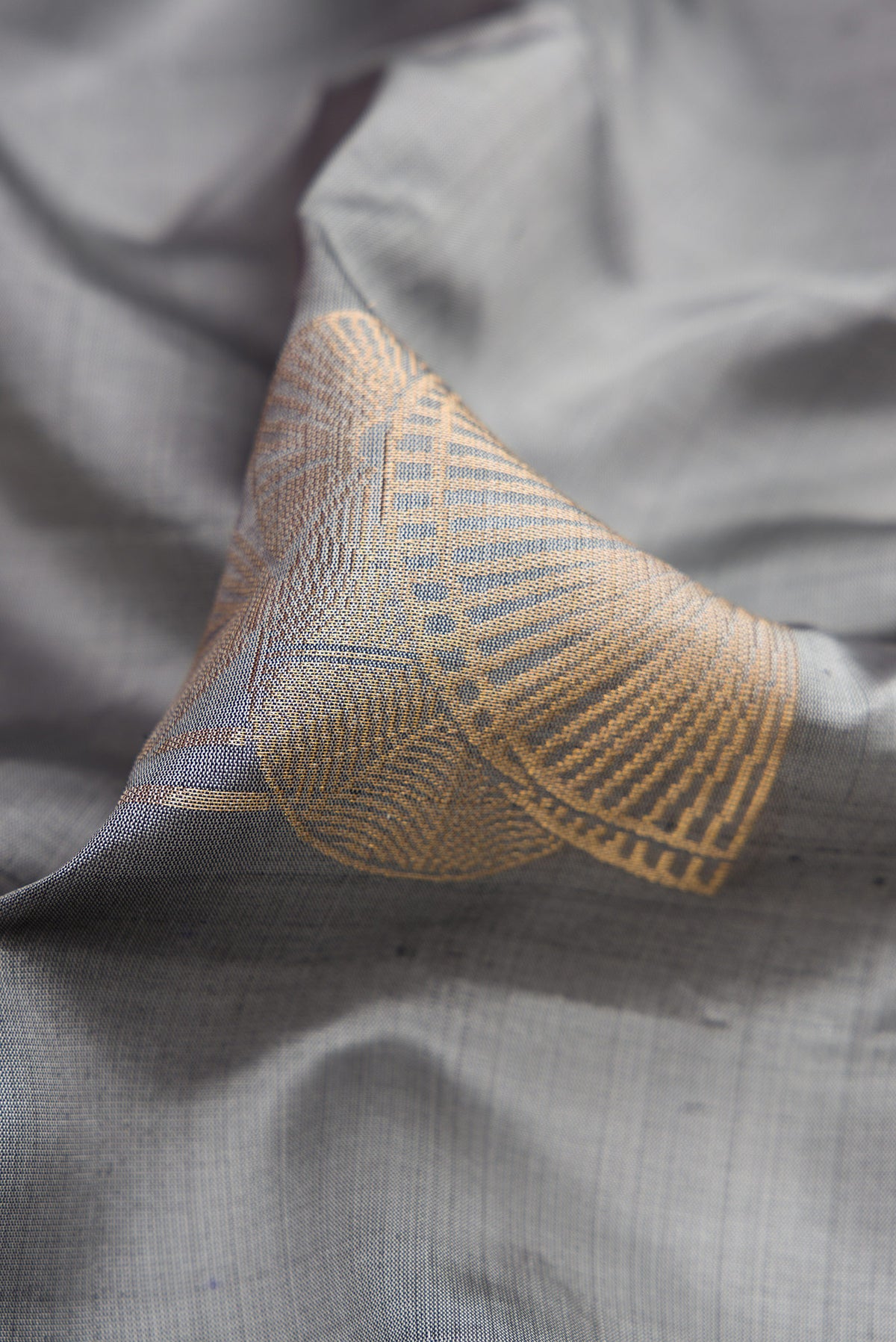Close up of Grey Dual Tone Soft Silk Saree with Zari Butta on the body and Without Border.  displaying folds