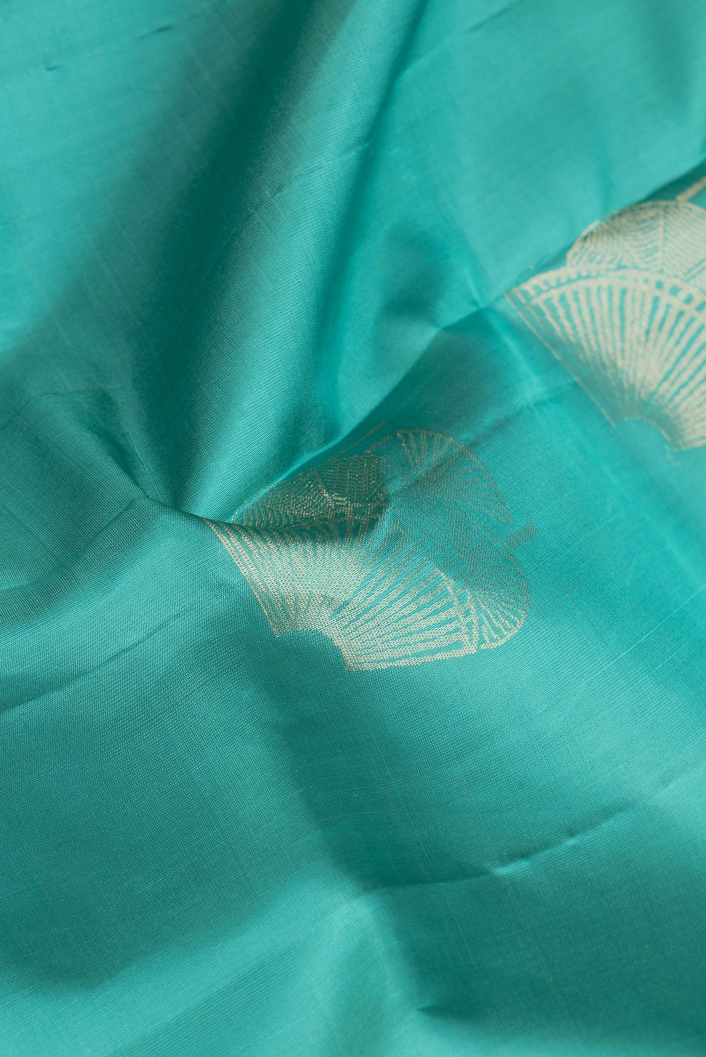 Close up of Sea Green Dual Tone Soft Silk Saree with Zari Butta on the body and Without Border.  displaying folds