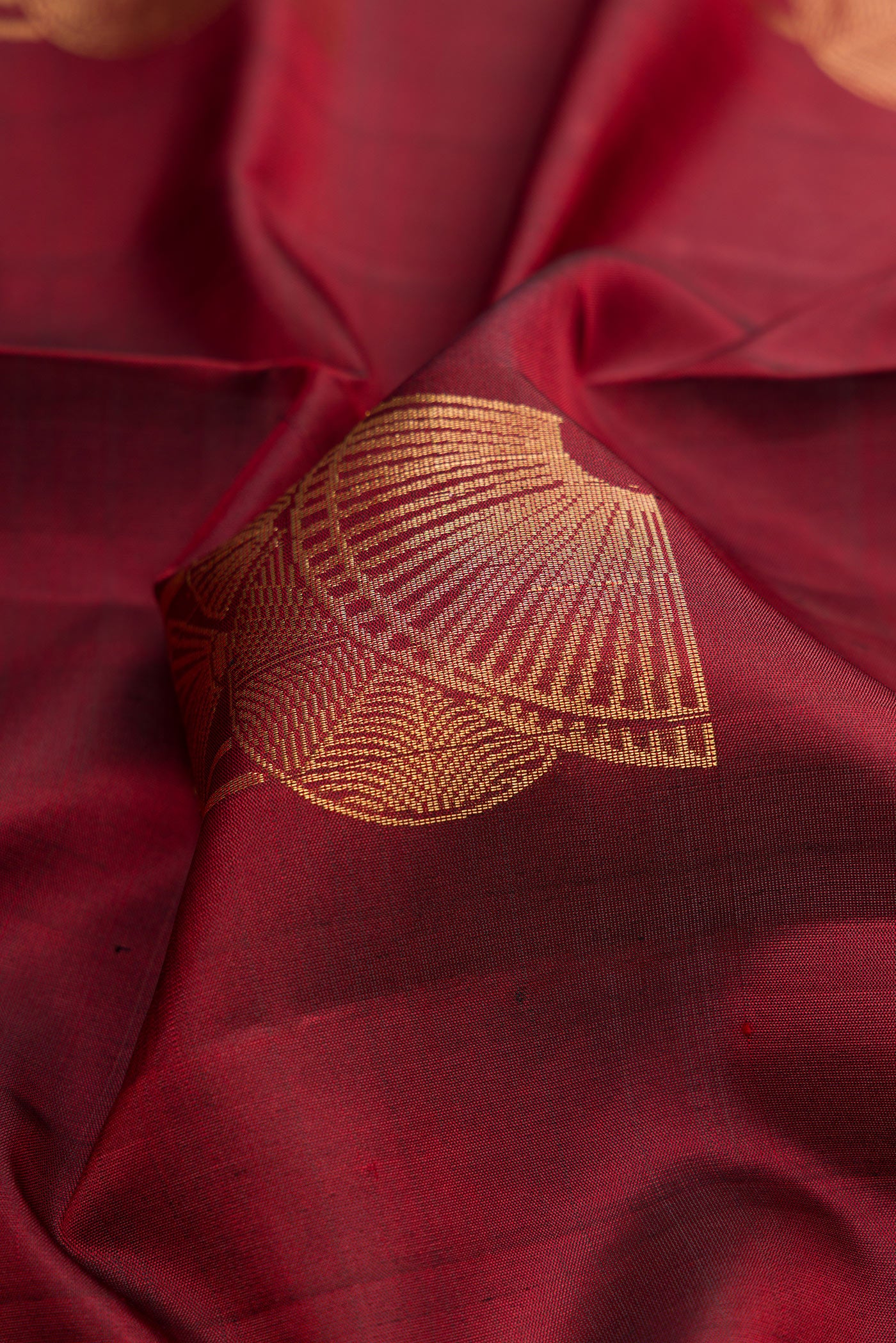 Close up of Maroon Dual Tone Soft Silk Saree with Zari Butta on the body and Zari Border.  displaying folds