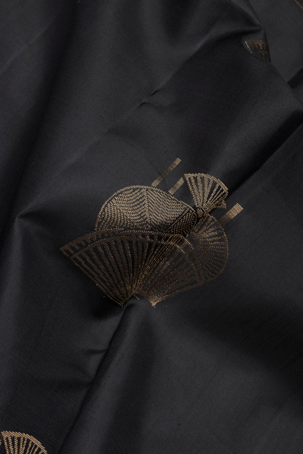 Close up of Black Soft Silk Saree with Zari Butta on the body and Without Border.  displaying folds