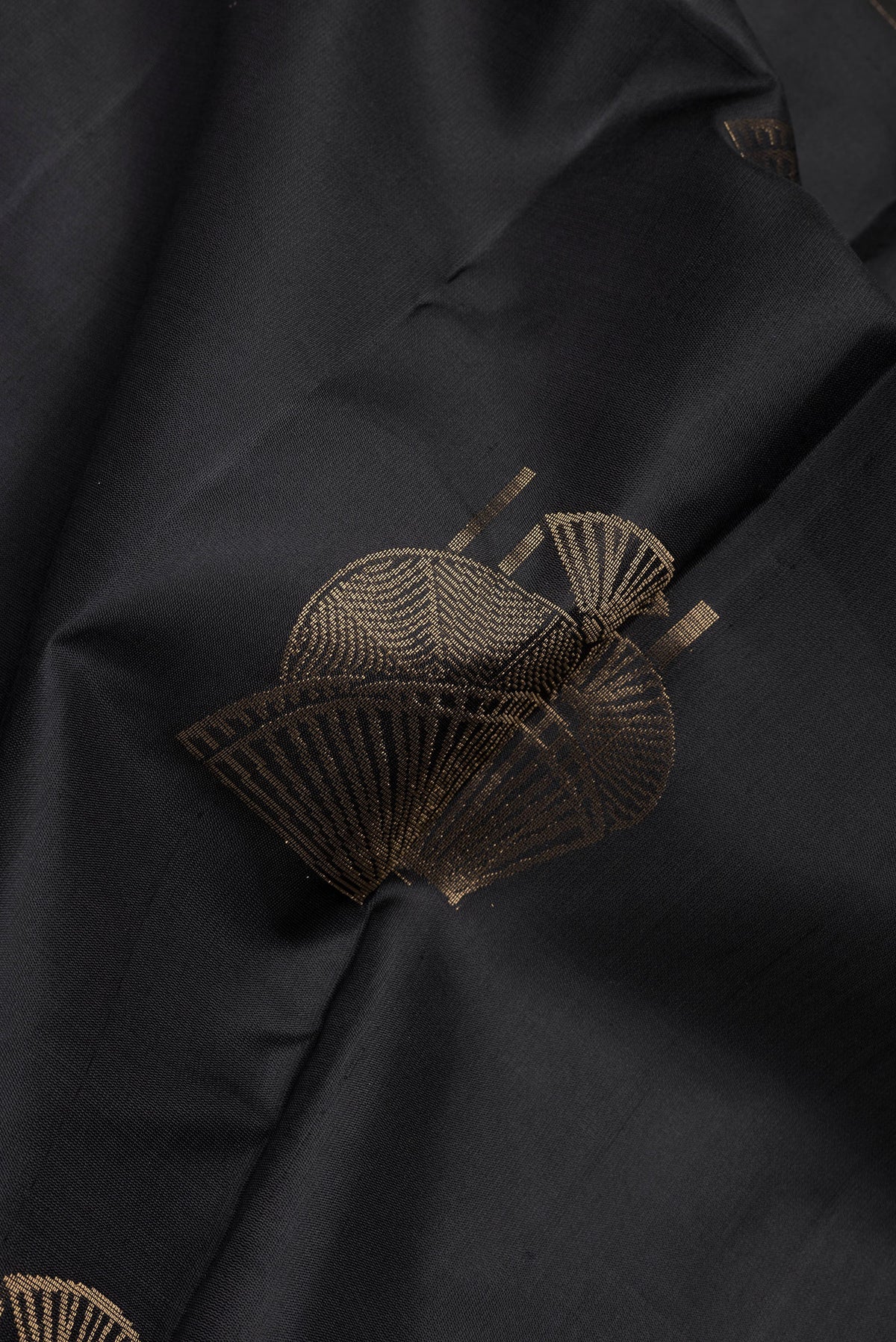 Close up of Black Soft Silk Saree with Zari Butta on the body and Without Border.  displaying folds