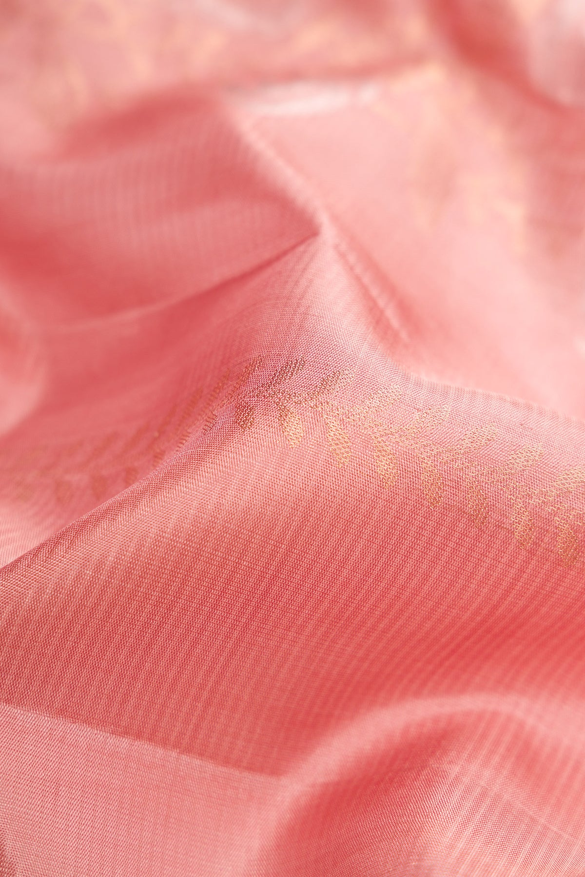 Close up of Golden Peach Dual Tone Soft Silk Saree with Zari Butta on the body and Zari Border.  displaying folds