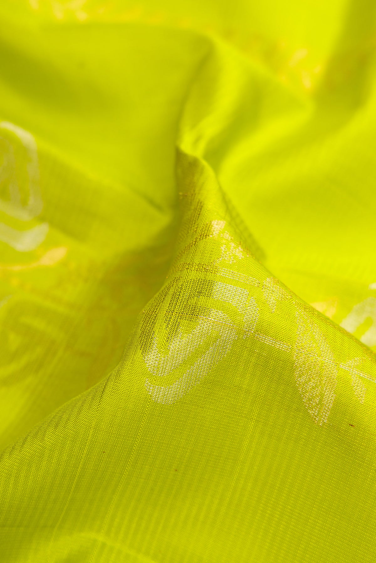 Close up of Parrot Green Dual Tone Soft Silk Saree with Zari Butta on the body and Zari Border.  displaying folds