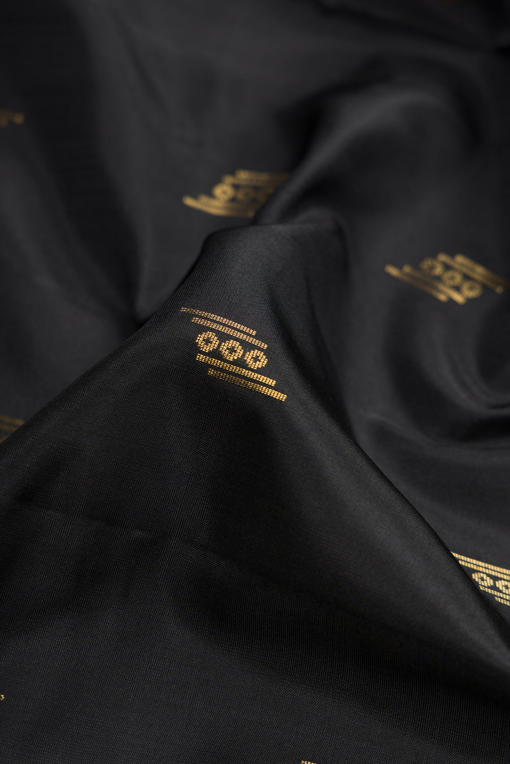Close up of Black Dual Tone Soft Silk Saree with Zari Butta on the body and Zari Border.  displaying folds