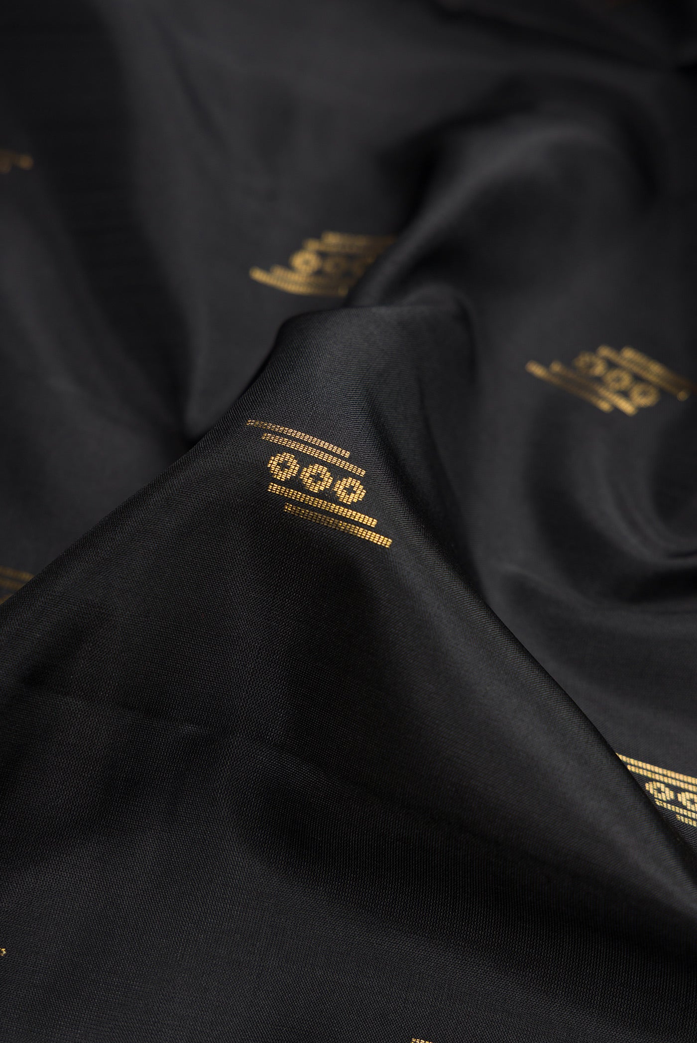 Close up of Black Dual Tone Soft Silk Saree with Zari Butta on the body and Zari Border.  displaying folds