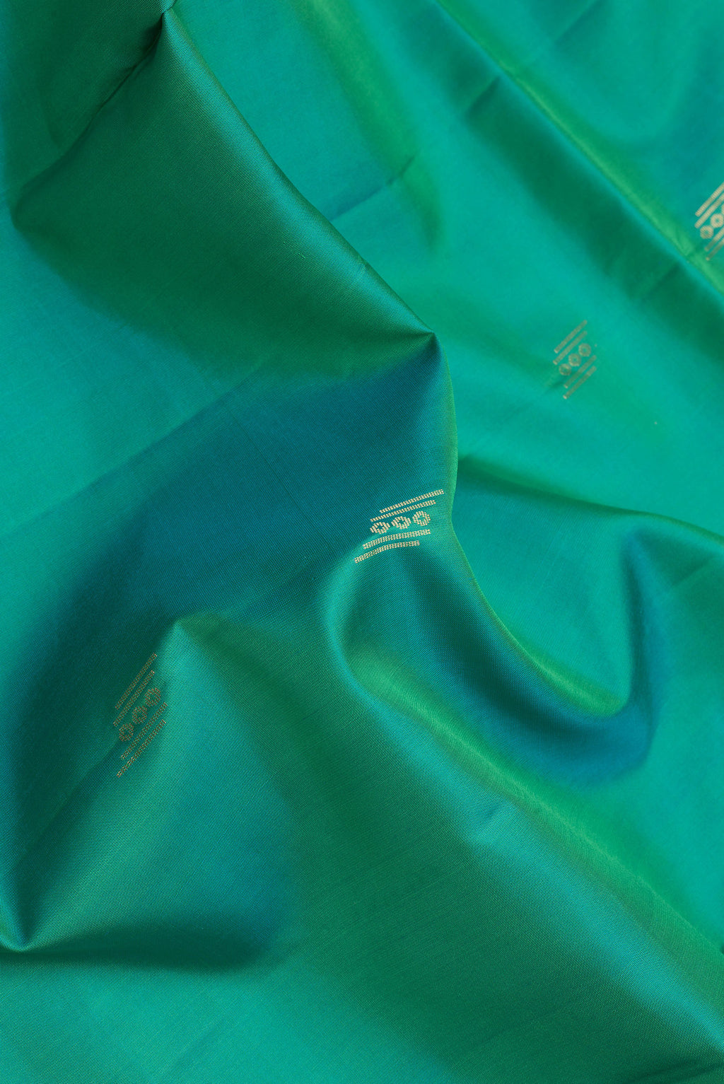 Close up of Sea Green Dual Tone Soft Silk Saree with Zari Butta on the body and Zari Border.  displaying folds