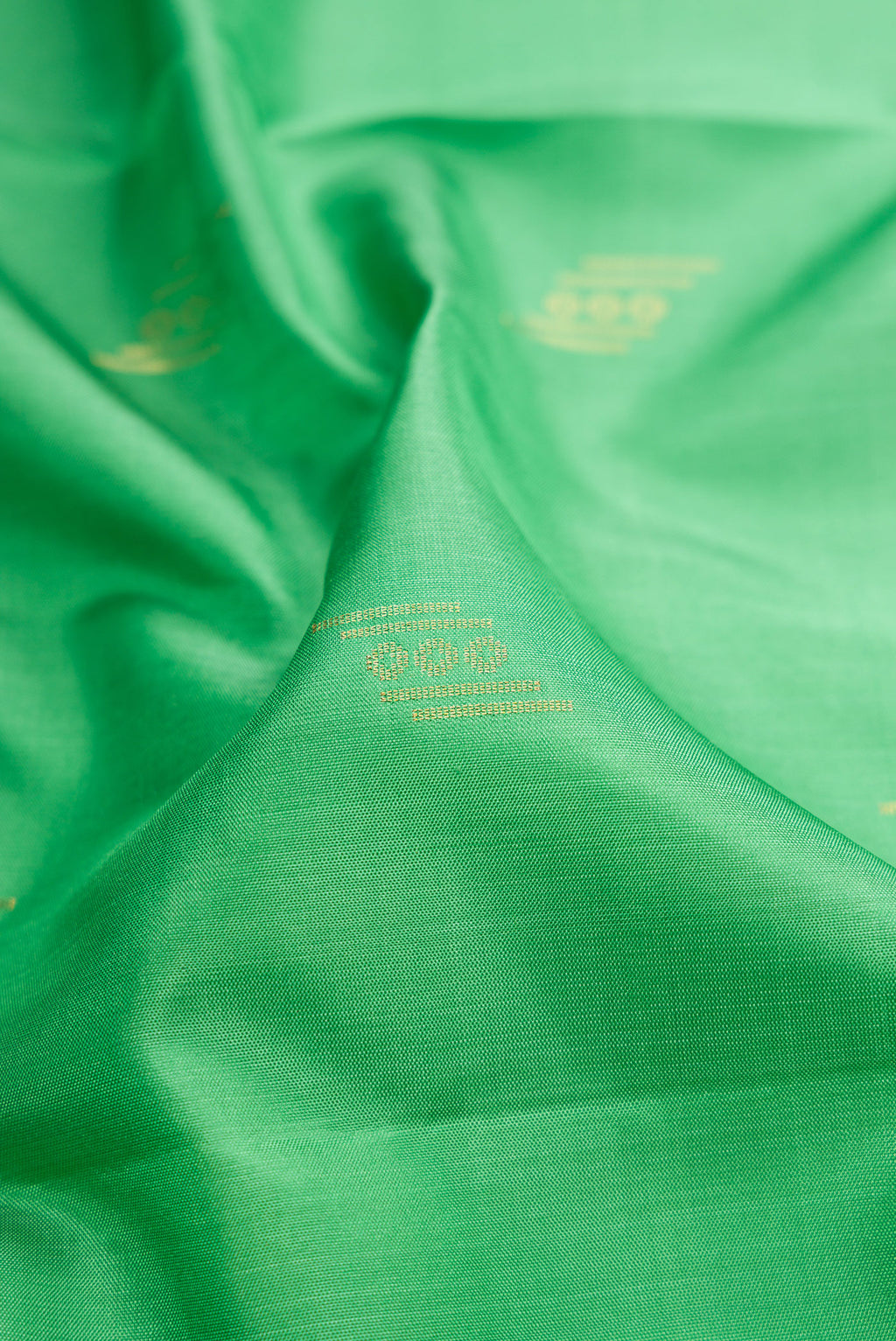 Close up of Pista Green Dual Tone Soft Silk Saree with Zari Butta on the body and Zari Border.  displaying folds