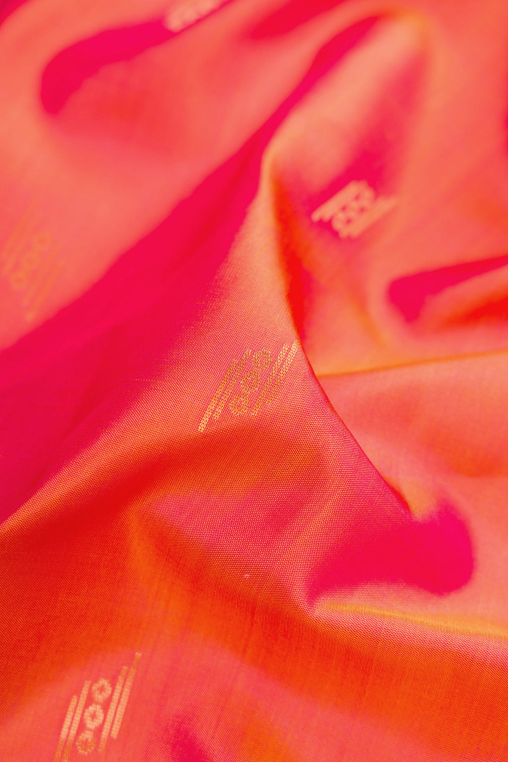Close up of Coral Dual Tone Soft Silk Saree with Zari Butta on the body and Zari Border.  displaying folds