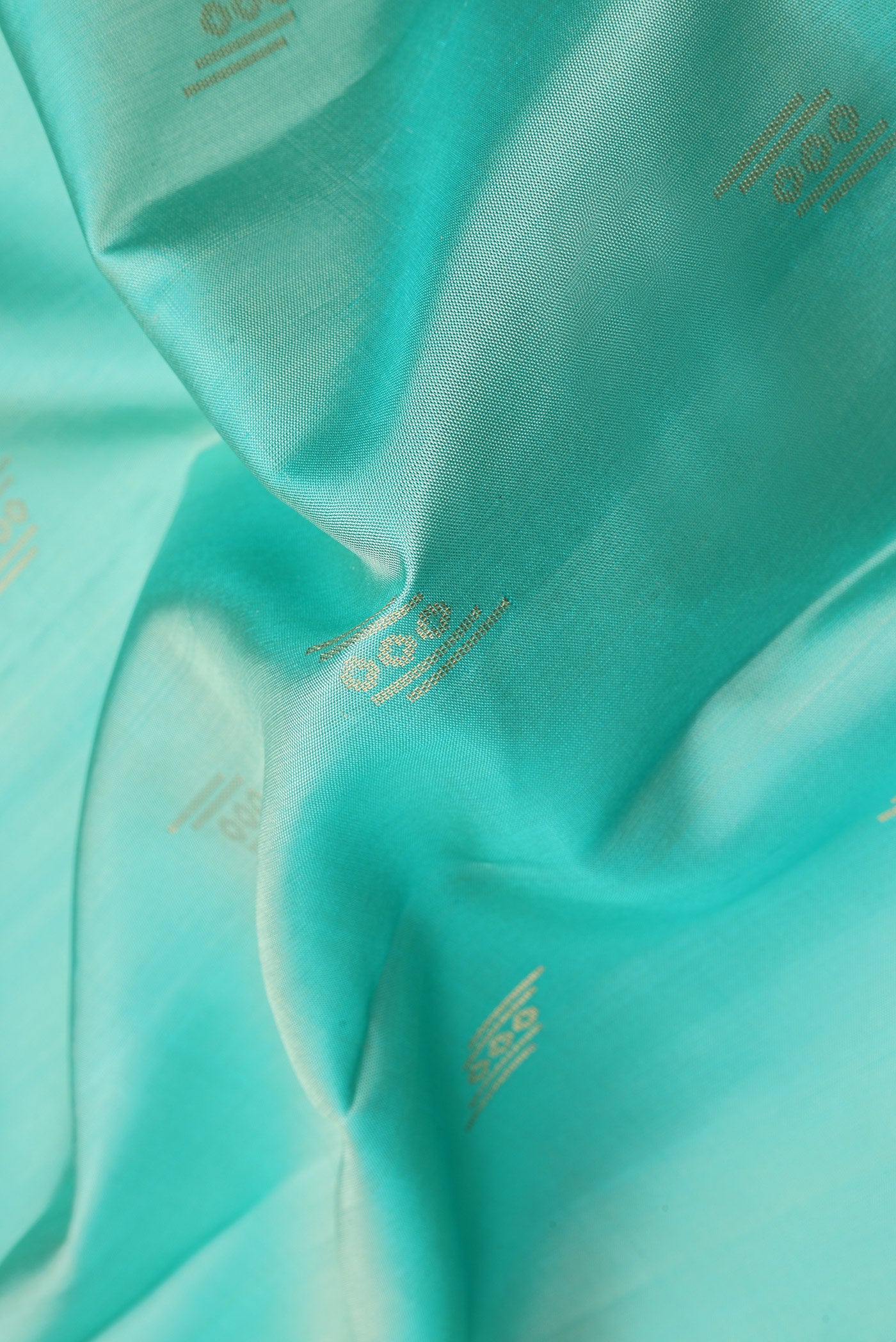 Close up of Sky Blue Soft Silk Saree with Zari Butta on the body and Zari Border.  displaying folds