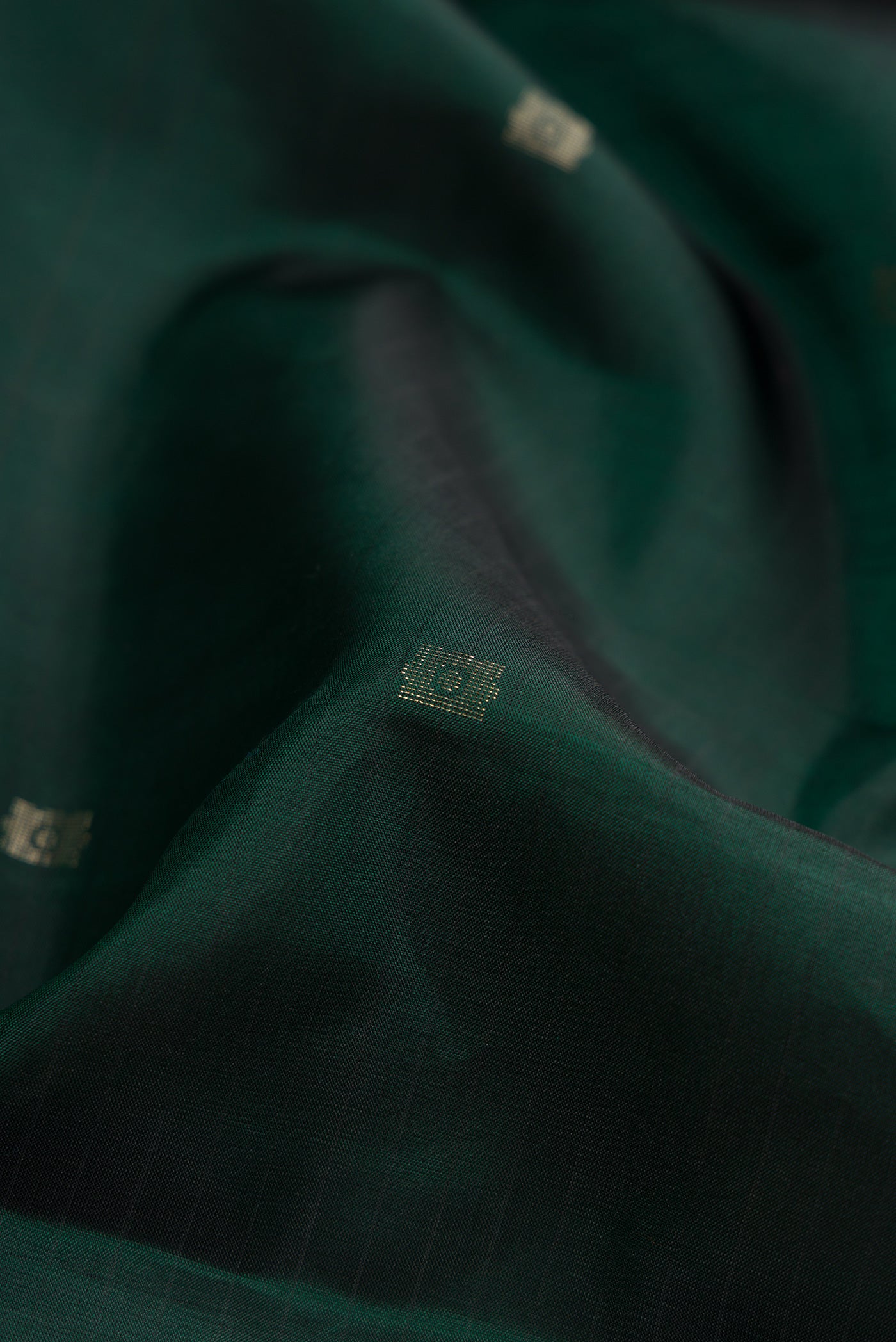Close up of Bottle Green Dual Tone Soft Silk Saree with Zari Butta on the body and Fancy Border.  displaying folds
