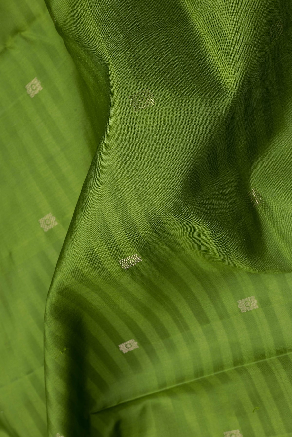 Close up of Green Soft Silk Saree with Zari Butta on the body and Fancy Border.  displaying folds
