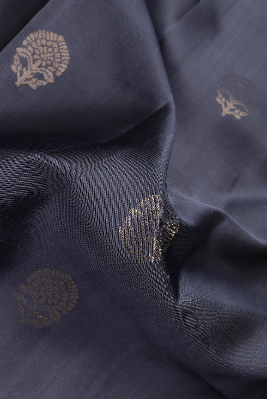 Close up of Grey Dual Tone Soft Silk Saree with Zari Butta on the body and Zari Border.  displaying folds