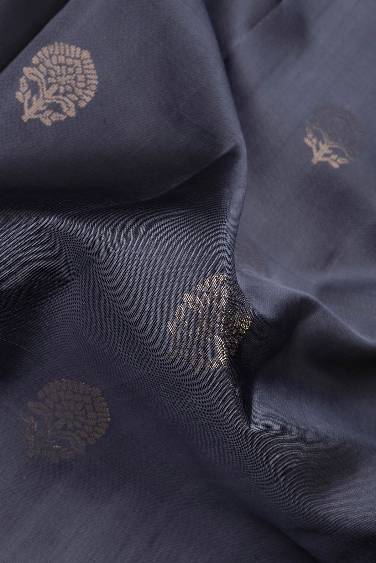 Close up of Grey Dual Tone Soft Silk Saree with Zari Butta on the body and Zari Border.  displaying folds