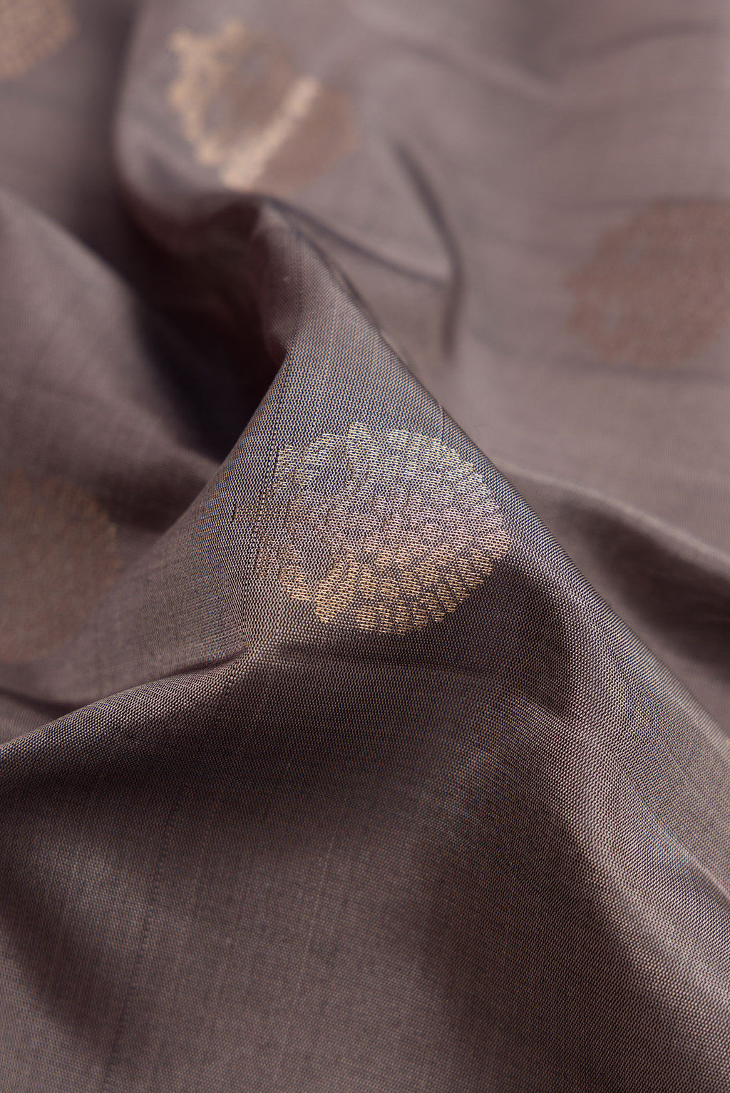 Close up of Grey Dual Tone Soft Silk Saree with Zari Butta on the body and Zari Border.  displaying folds