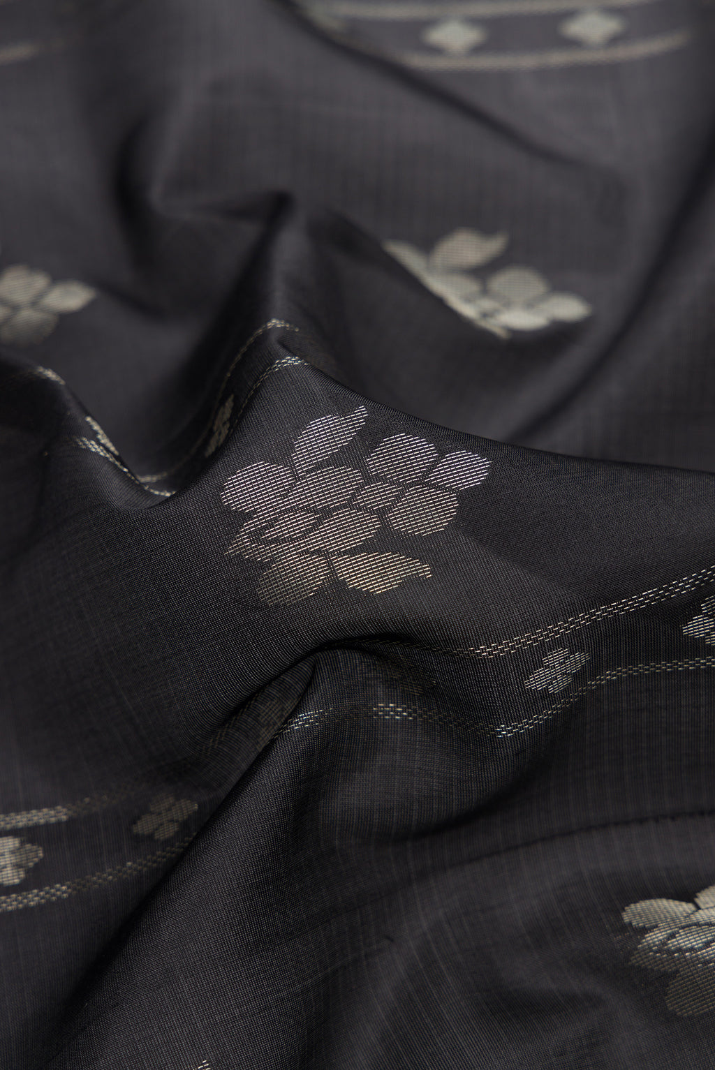 Close up of Black Dual Tone Soft Silk Saree with Zari Butta on the body and Zari Border.  displaying folds