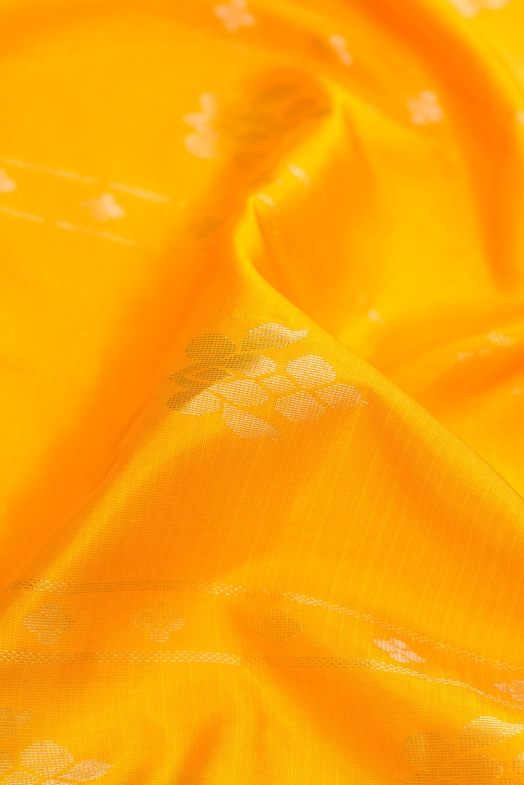 Close up of Yellow Dual Tone Soft Silk Saree with Zari Butta on the body and Zari Border.  displaying folds