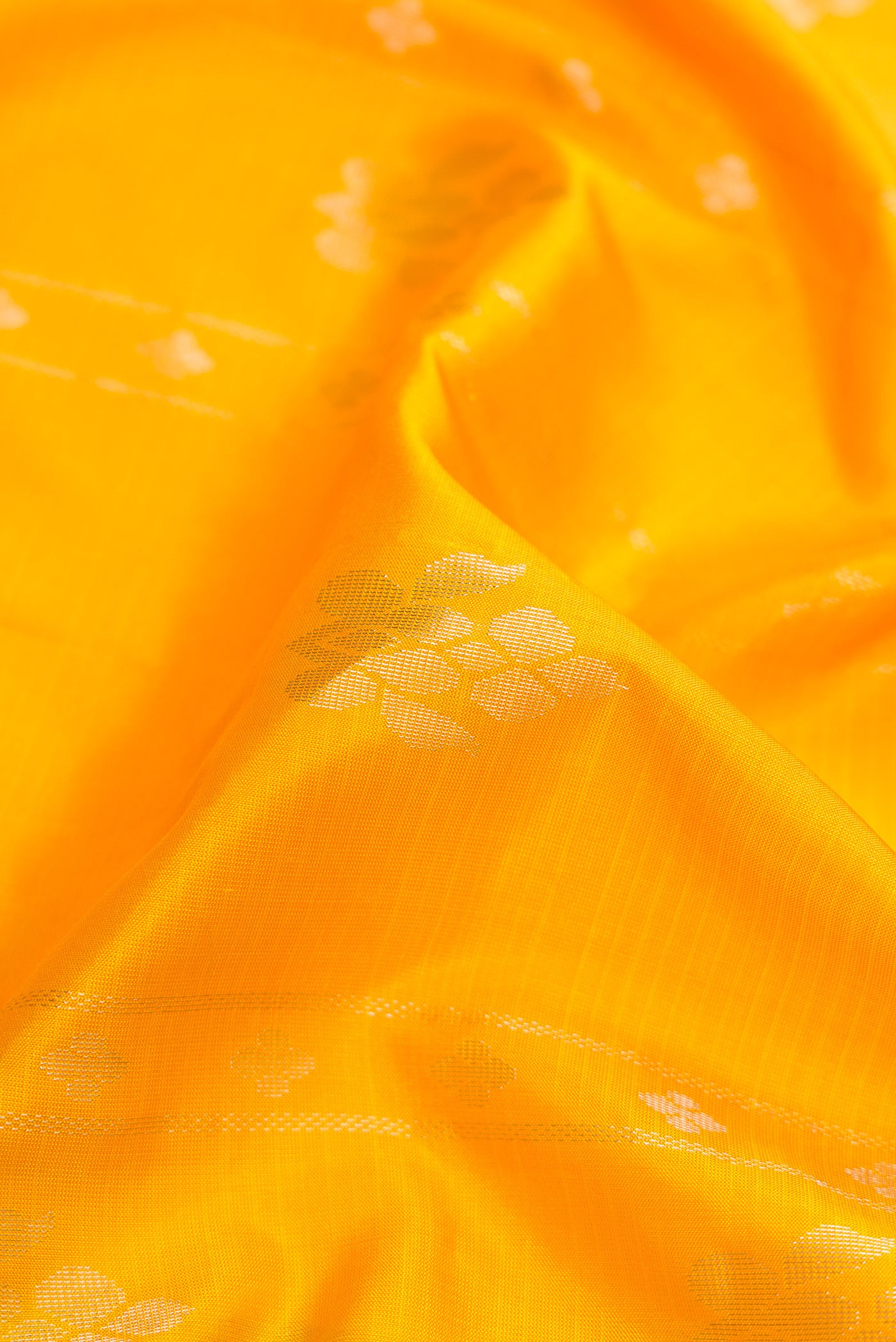 Close up of Yellow Dual Tone Soft Silk Saree with Zari Butta on the body and Zari Border.  displaying folds