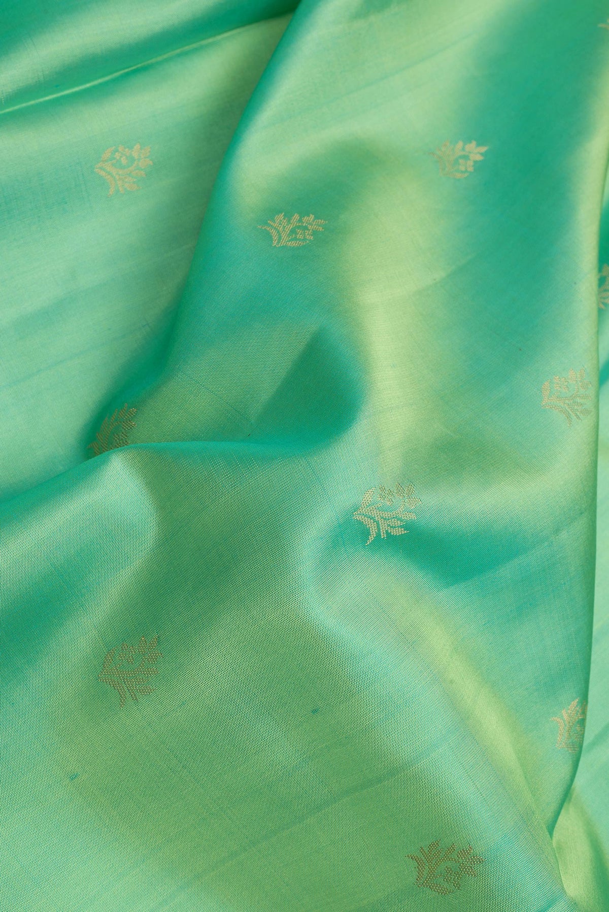 Close up of Sea Green Dual Tone Soft Silk Saree with Zari Butta on the body and Zari Border.  displaying folds